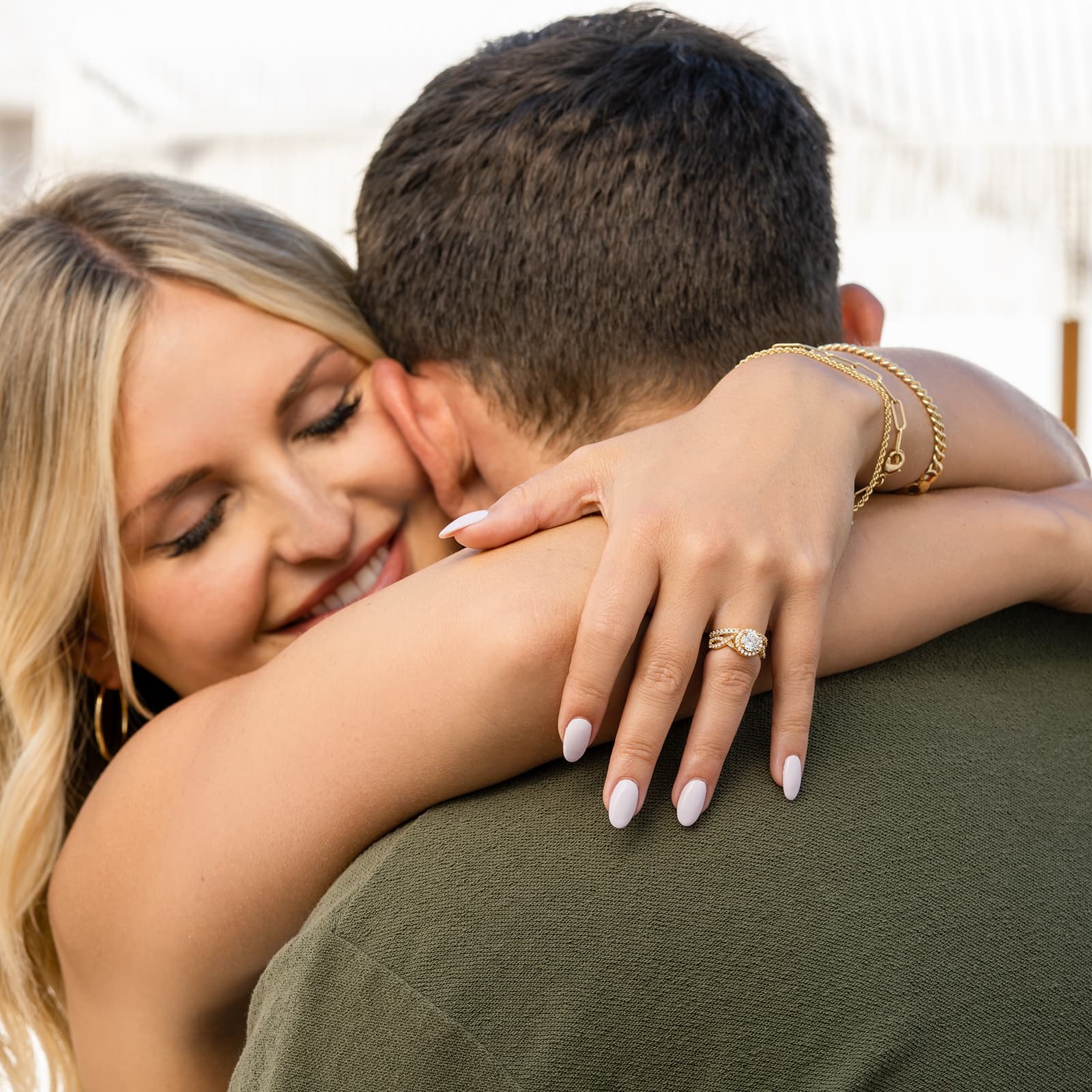 couple hugging wearing gold engagement ring