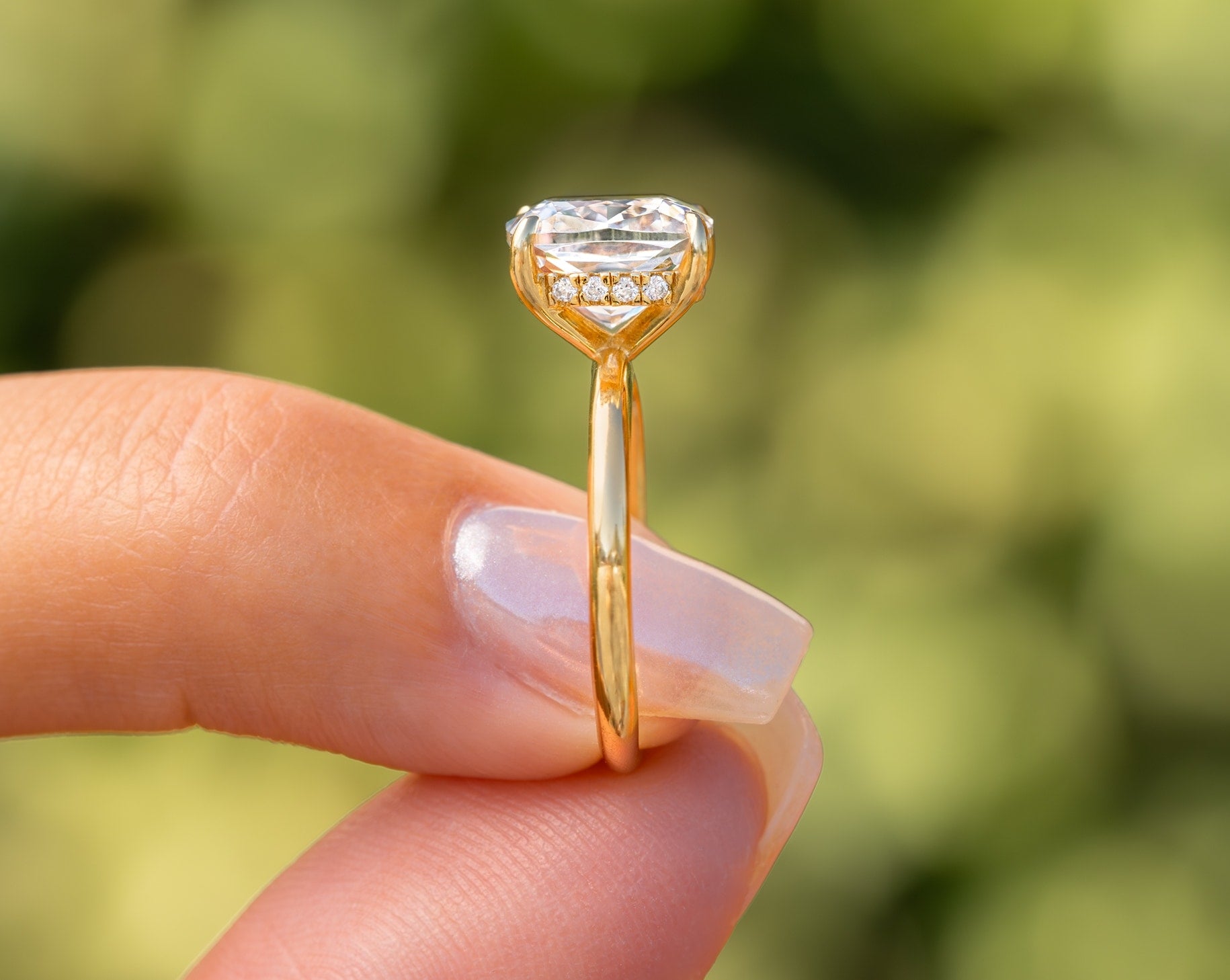 woman pinching gold engagement ring showing hidden halo
