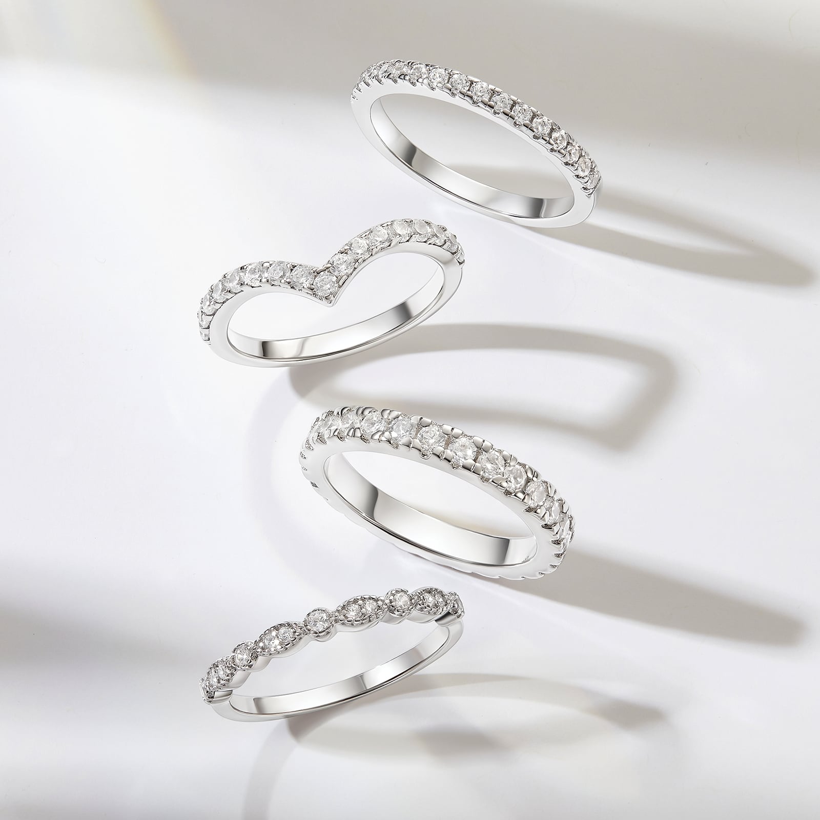 4 affordable silver wedding bands in a row on gray background