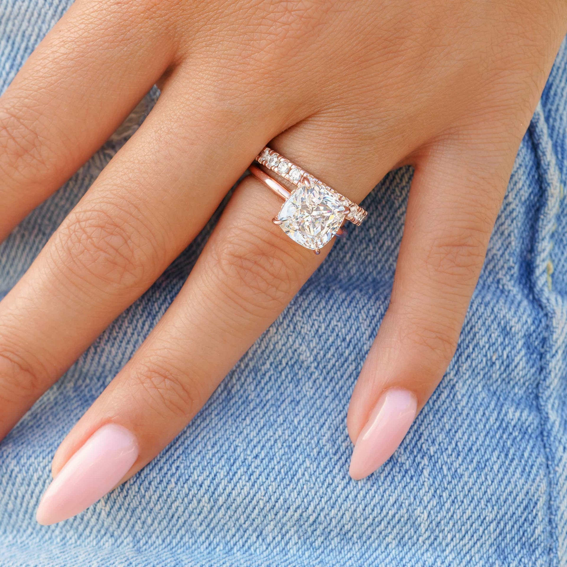 woman wearing rose gold wedding band with cushion cut engagement ring