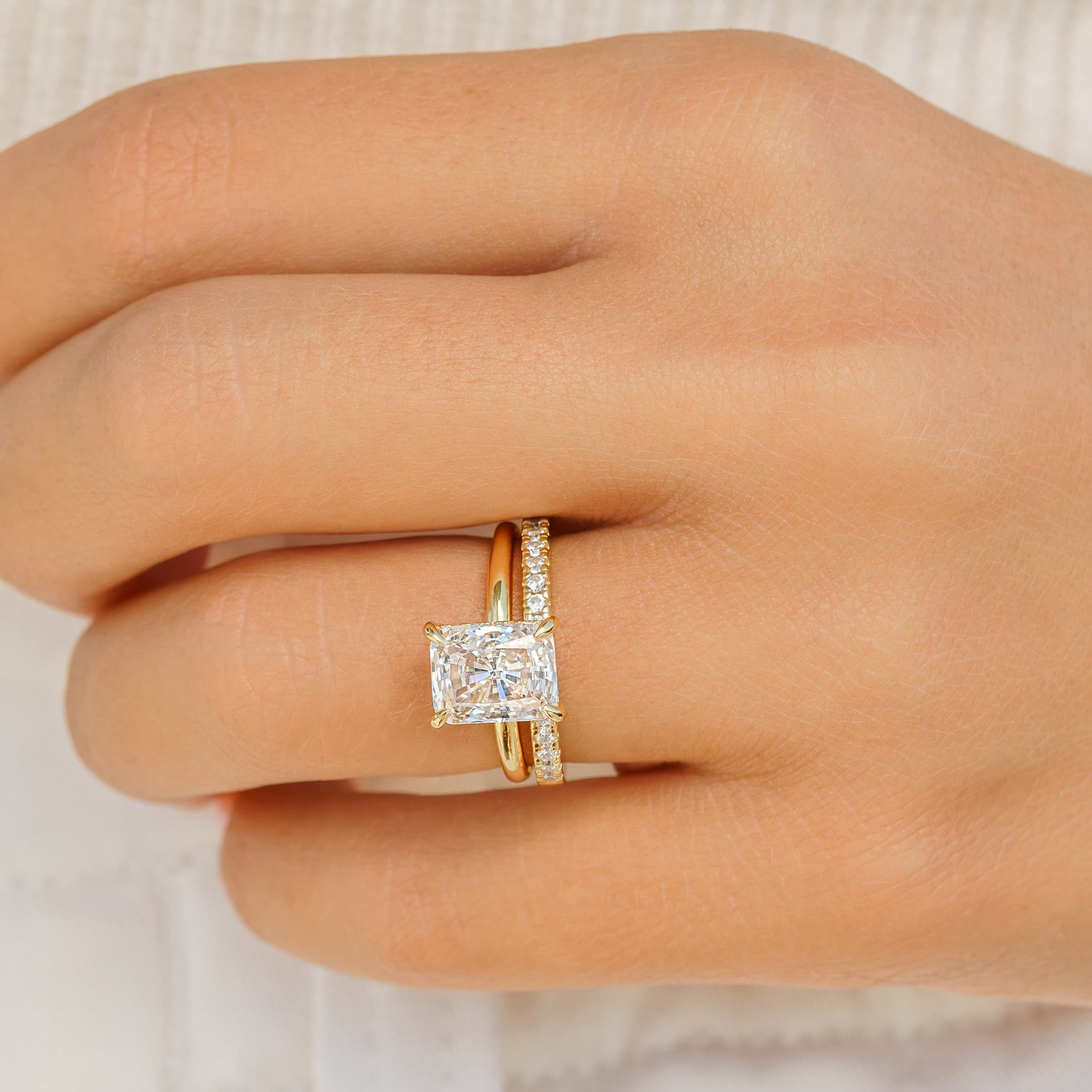 woman wearing radiant cut engagement ring with desire band