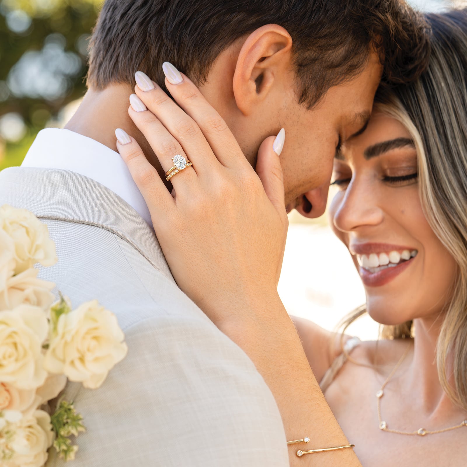 couple hugging wearing gold oval cut engagement ring