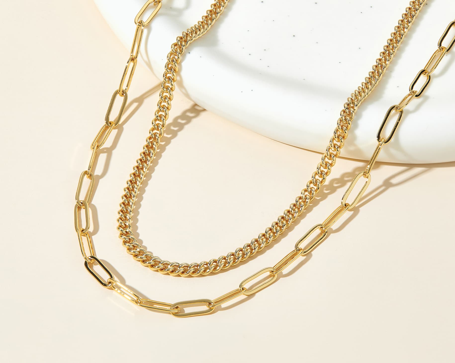 gold necklace stack on cream background