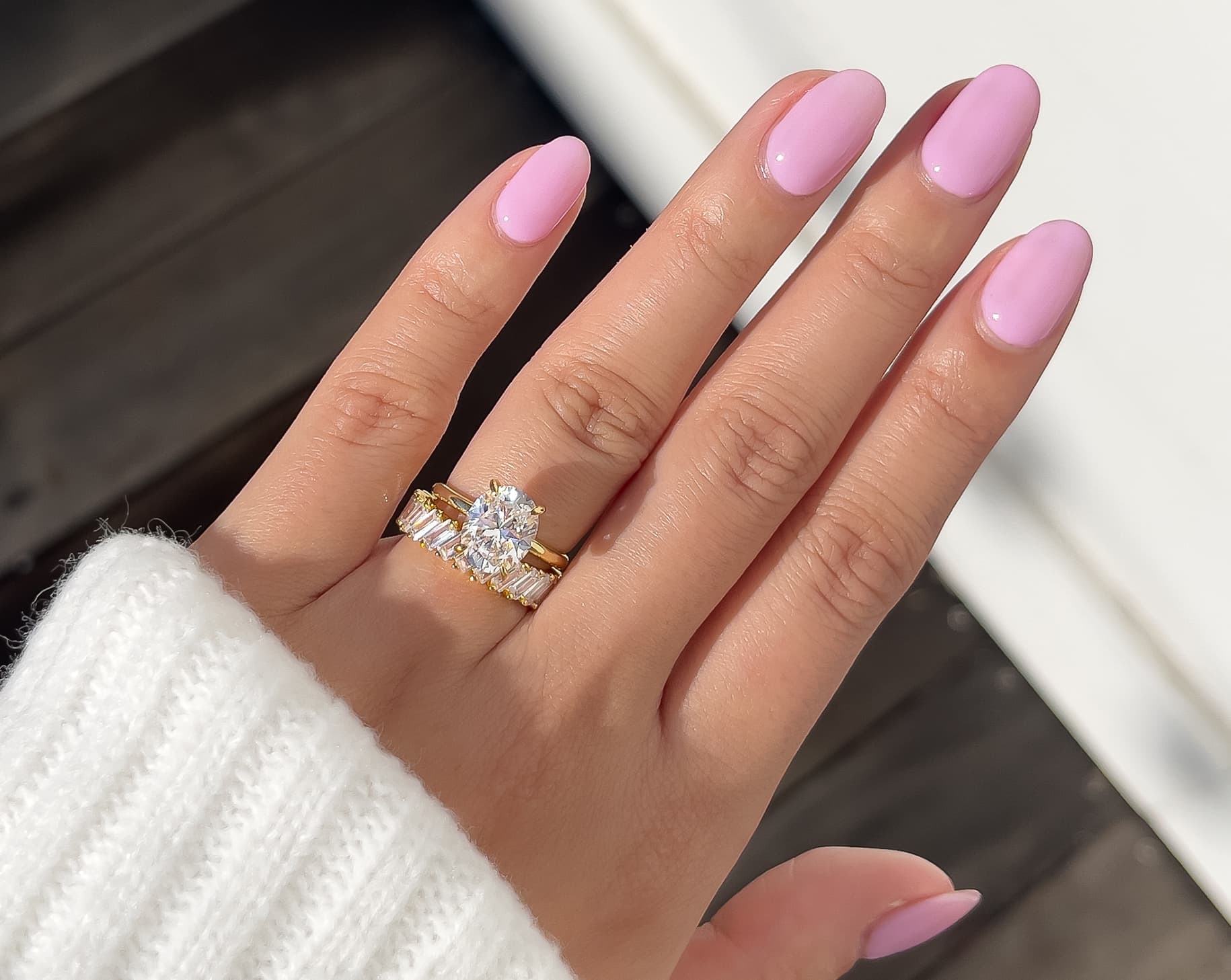 beautiful pov on ladies hand with oval cut engagement ring in gold
