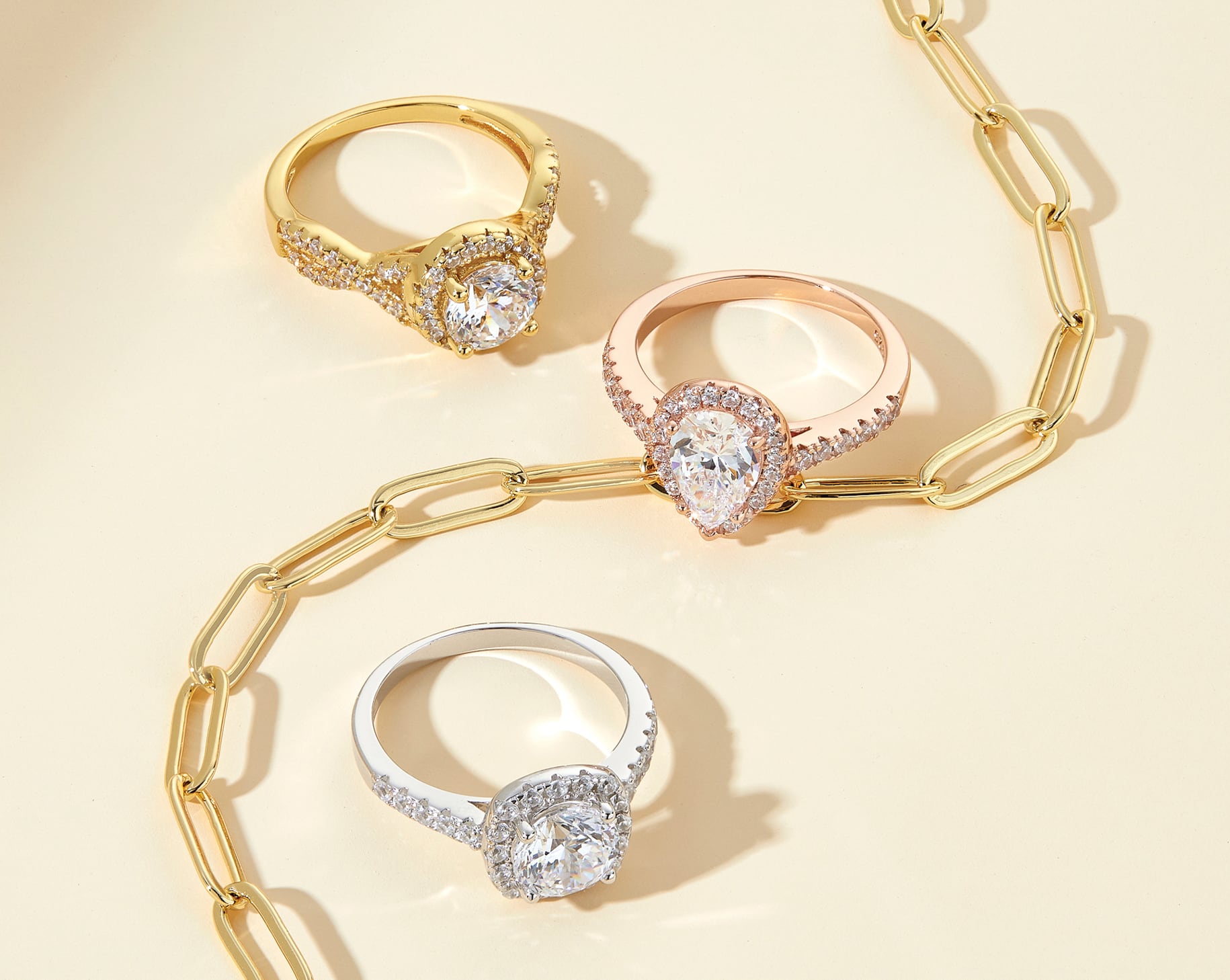 3 halo engagement rings shown in silver, rose gold, and gold