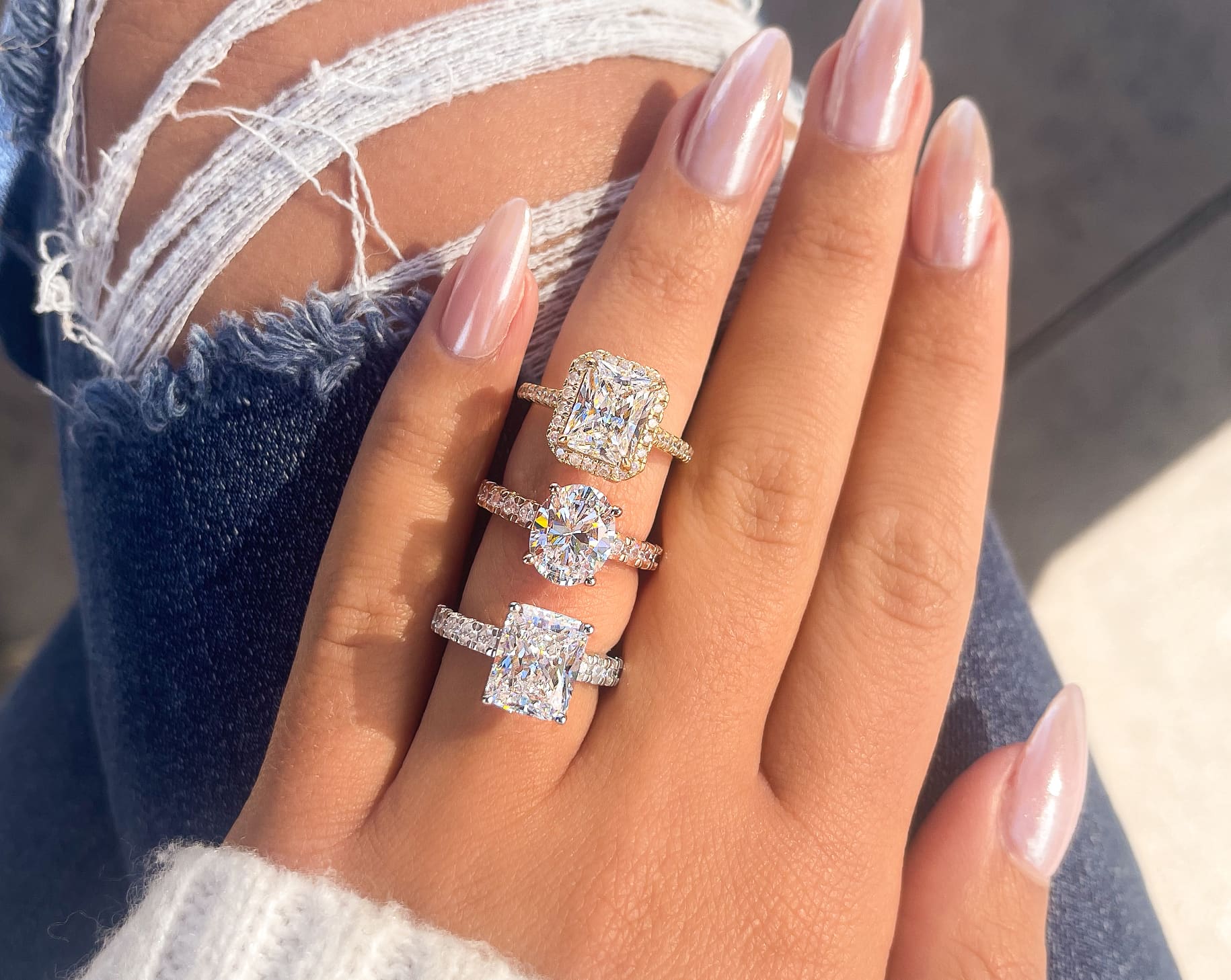 gorgeous 3 engagement rings shown on ladies hand in silver, rose gold, and gold