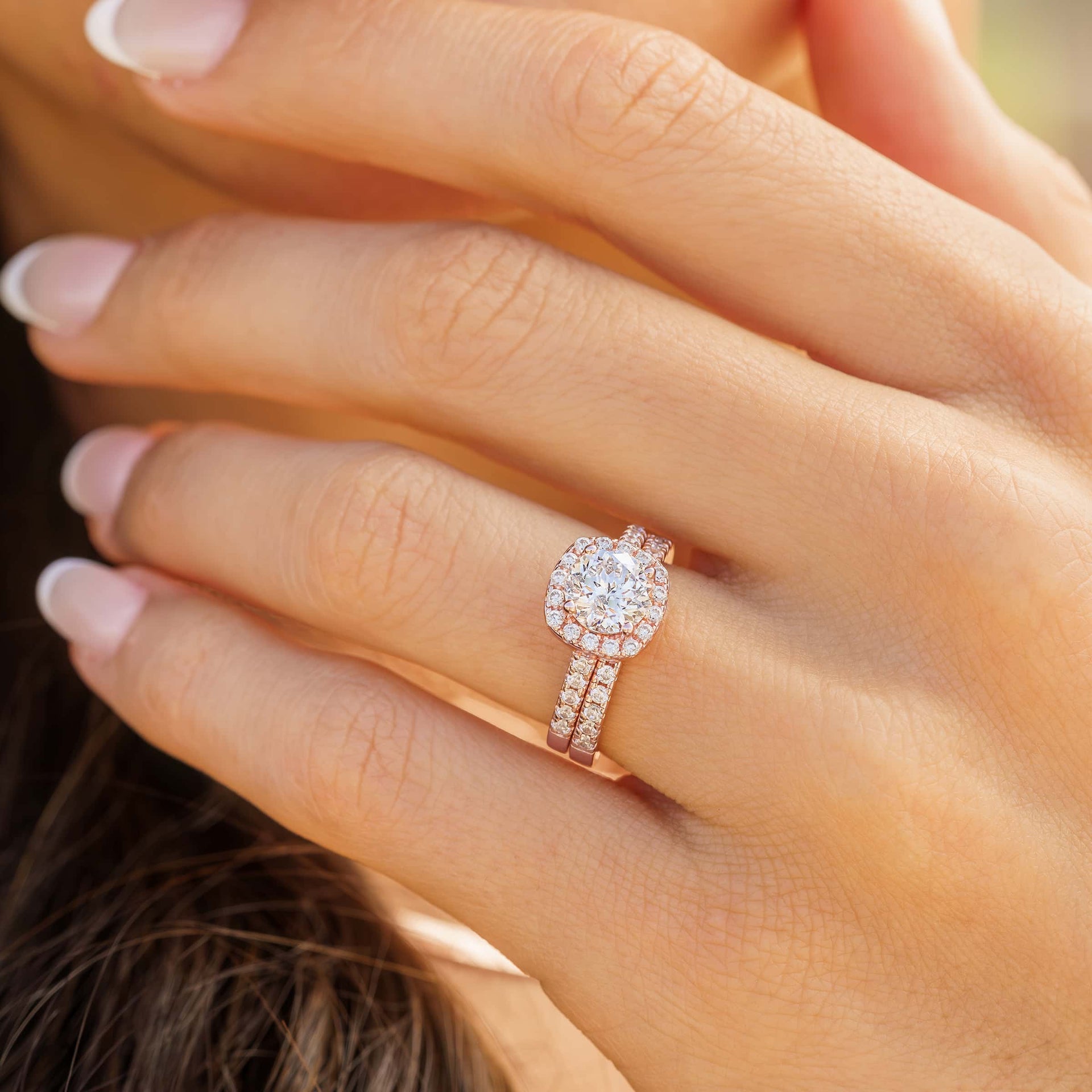 woman wearing rose gold cushion cut engagement ring set