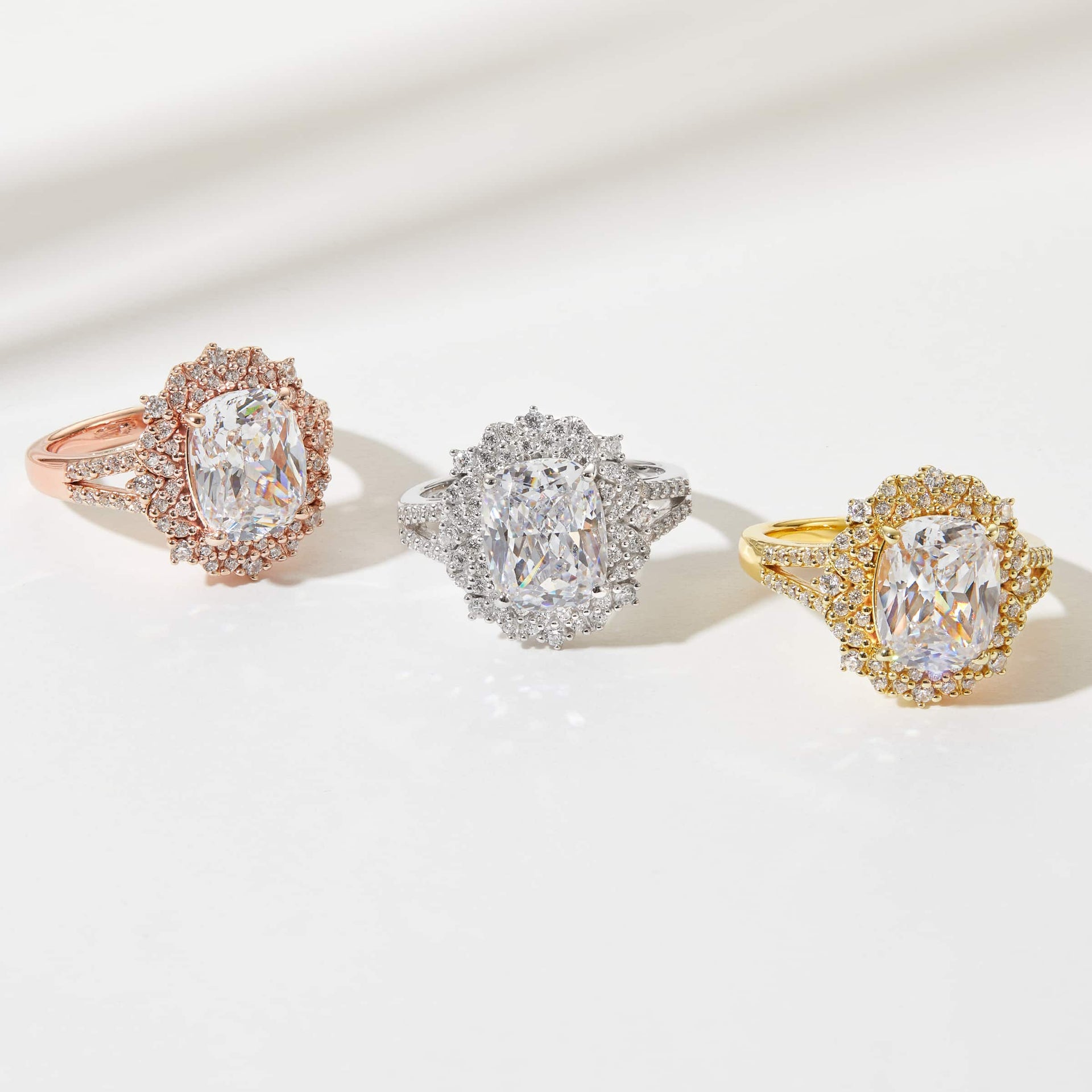 the sol engagement ring shown in rose gold, silver, and gold on a neutral background with light beams