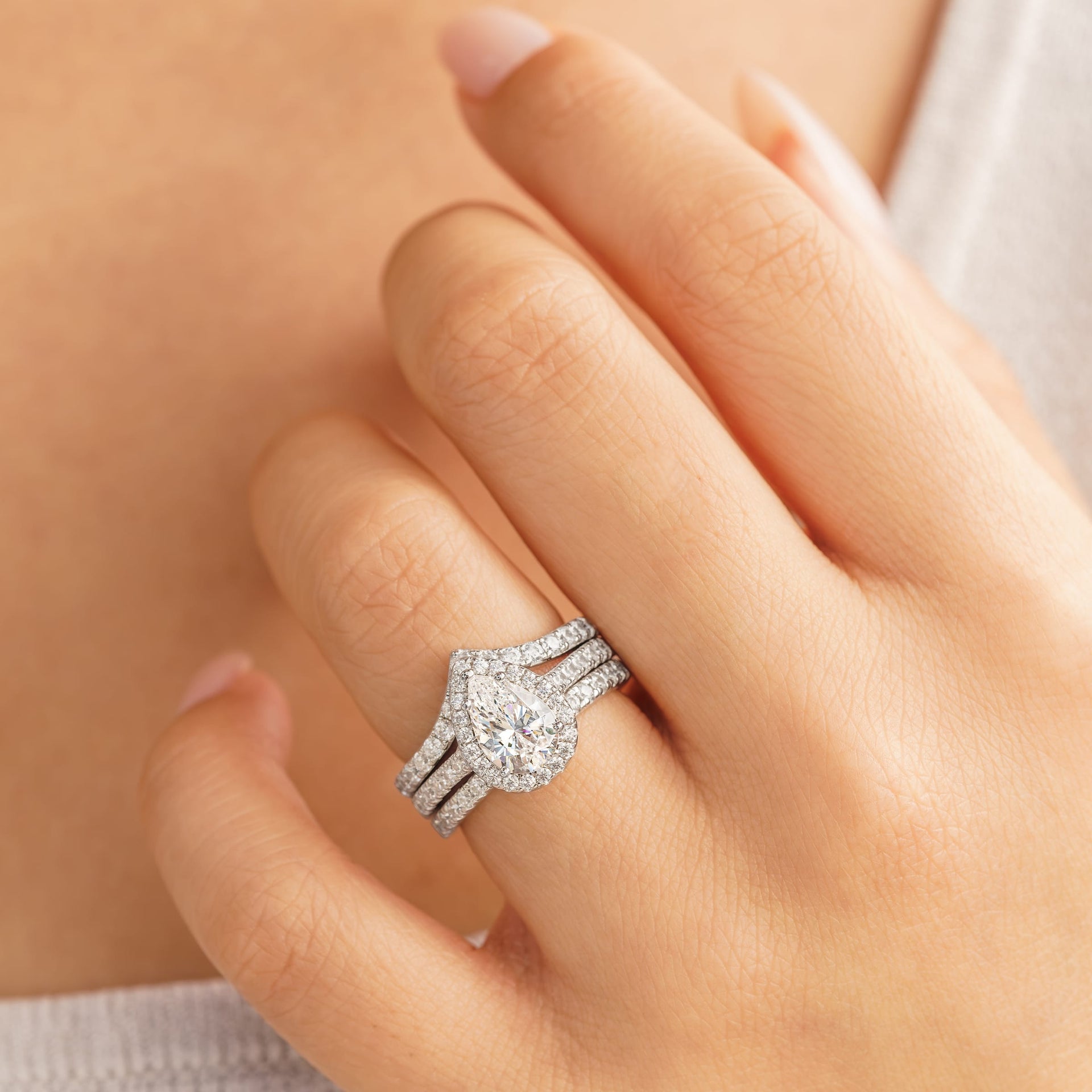 woman wearing triple stack with pear shaped engagement ring