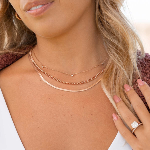 Dainty layered rose gold necklaces on model
