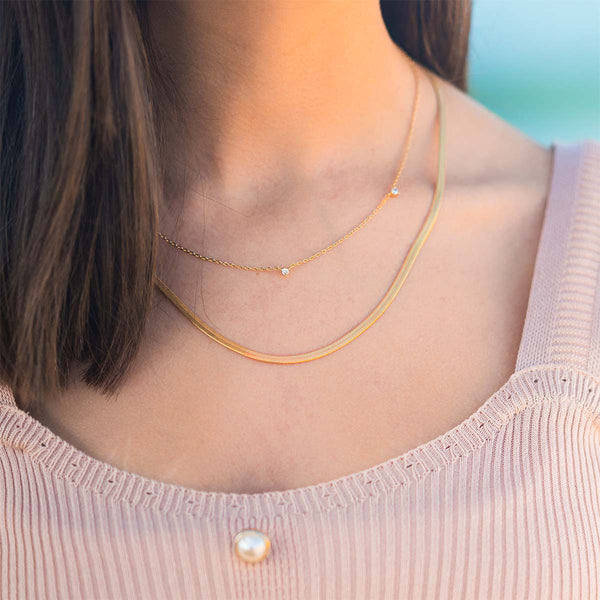 Dainty gold layered necklaces on model