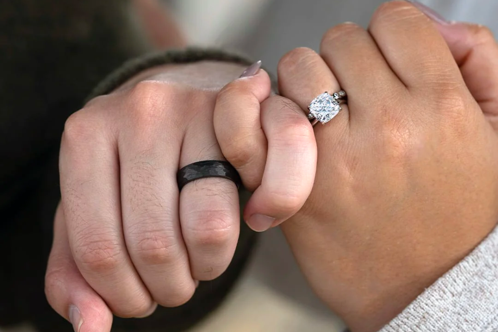 man and woman with rings holding pinky fingers