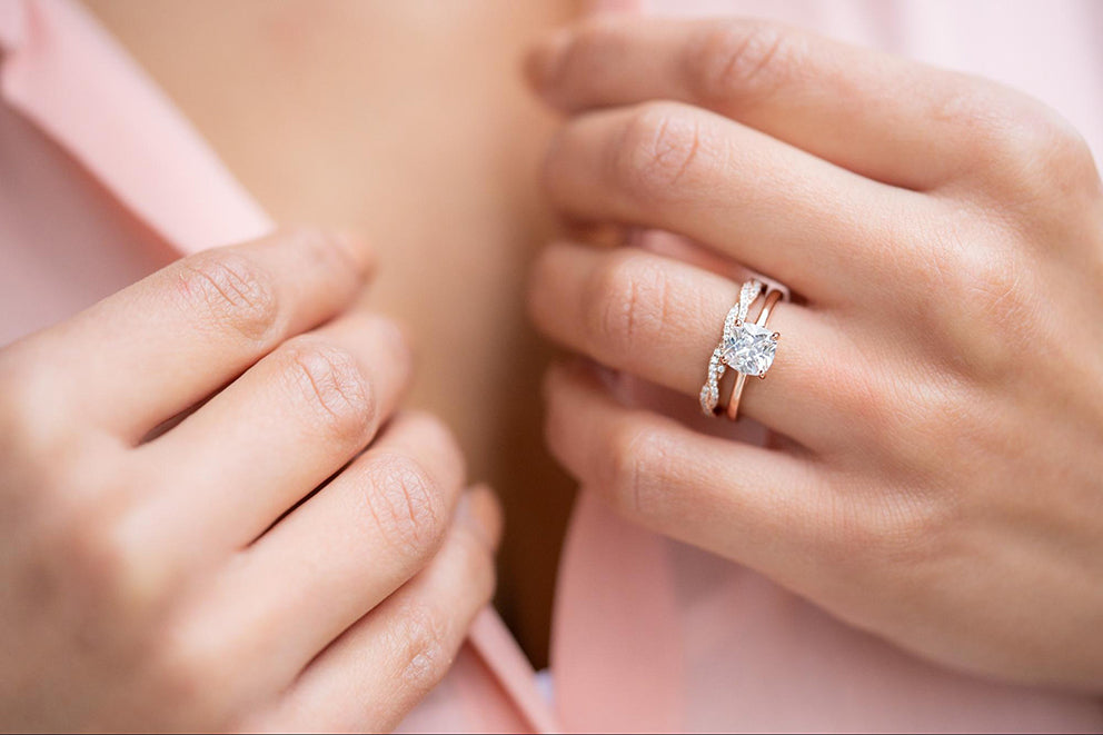 a woman wearing a dainty engagement ring holding her collar