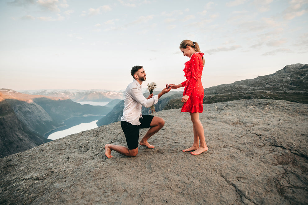 a man proposing to a woman on a cliff