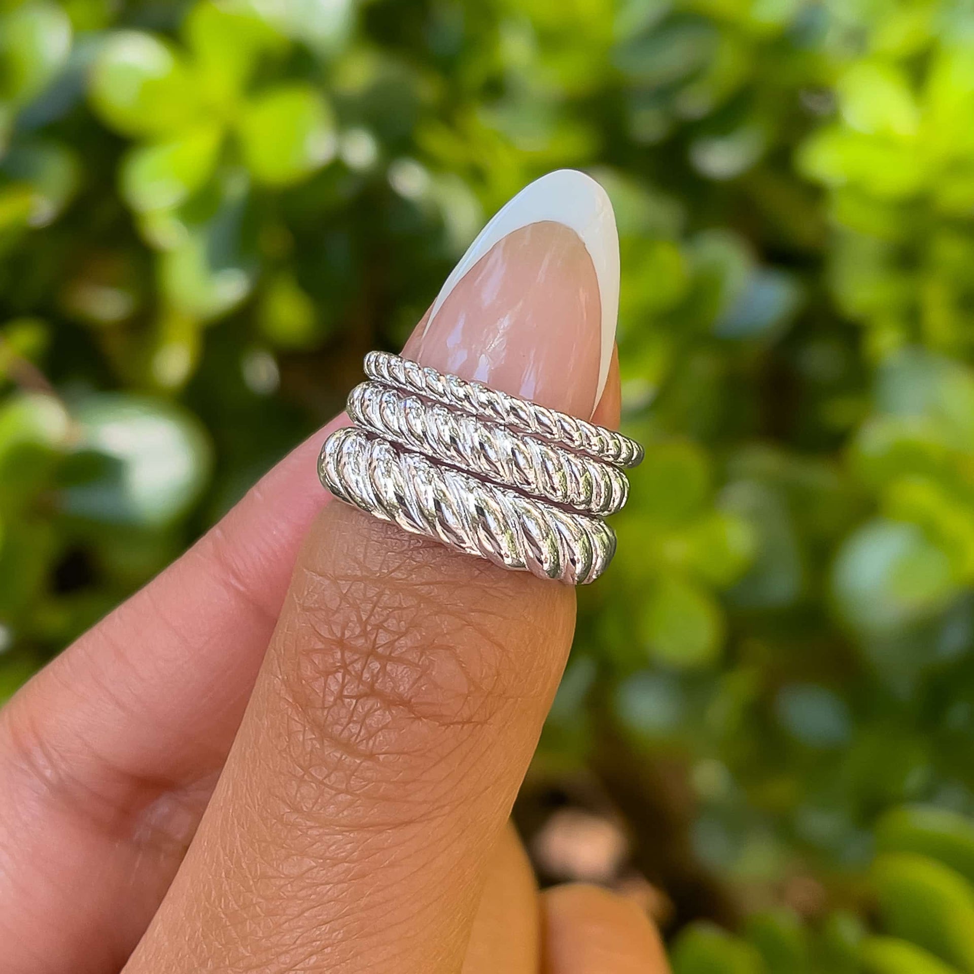 set of three silver rings featuring a twisting design, all in varying sizes