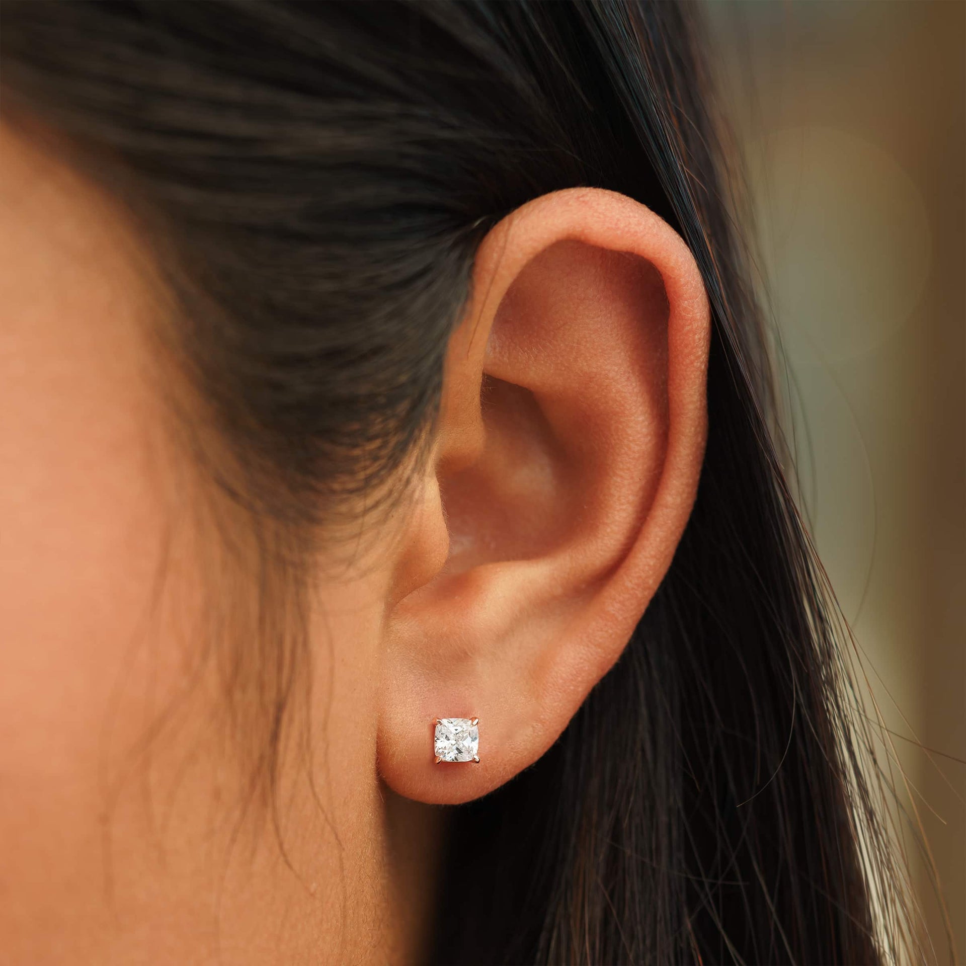 small rose gold cushion cut stud earrings on female model