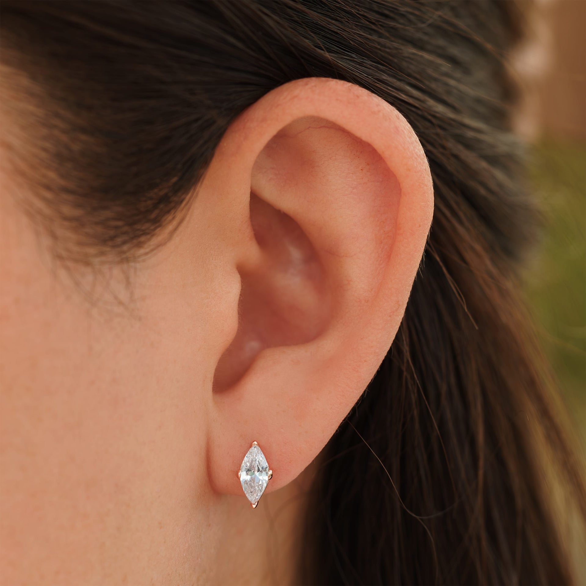 small rose gold marquise cut stud earrings on female model