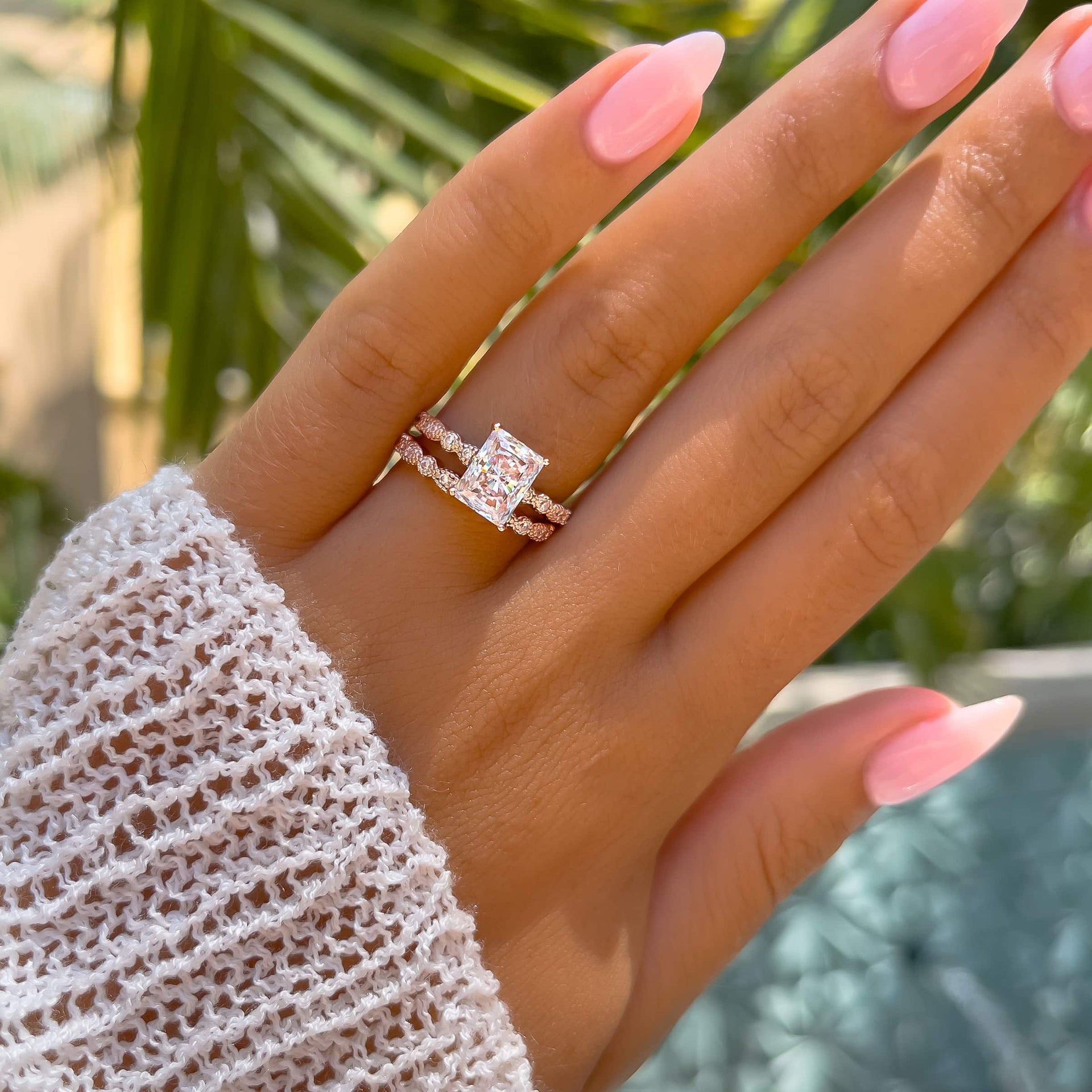 stunning rose gold vintage style engagement ring paired with matching rose gold wedding band on model with neutral pink nails and white sleeve