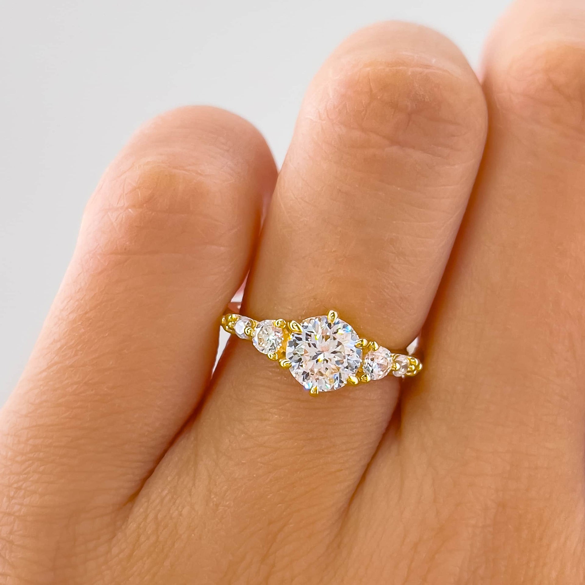 stunning gold 1.25 carat round cut engagement ring with vintage detailing on model