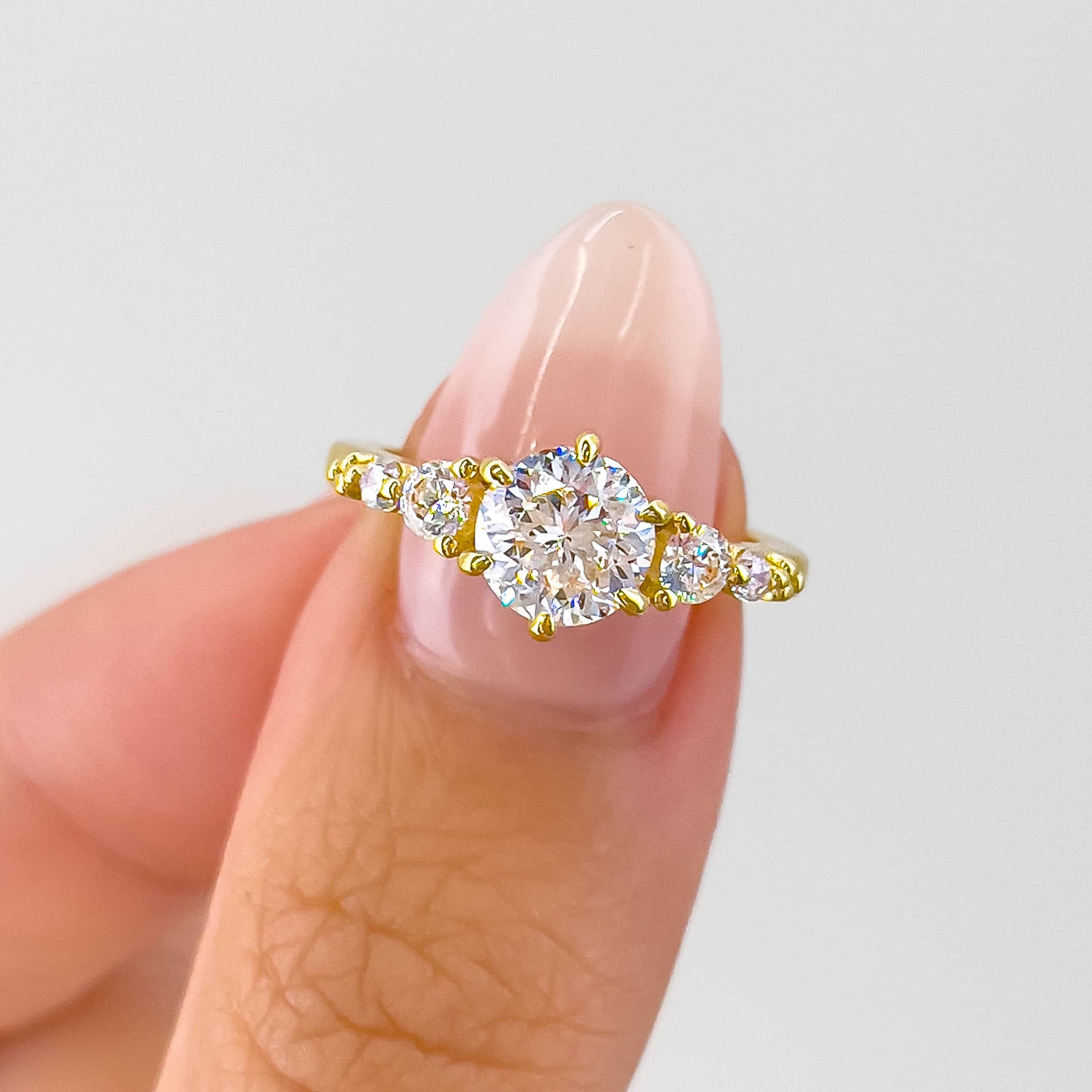 gorgeous gold round cut vintage style engagement ring on model with neutral nails