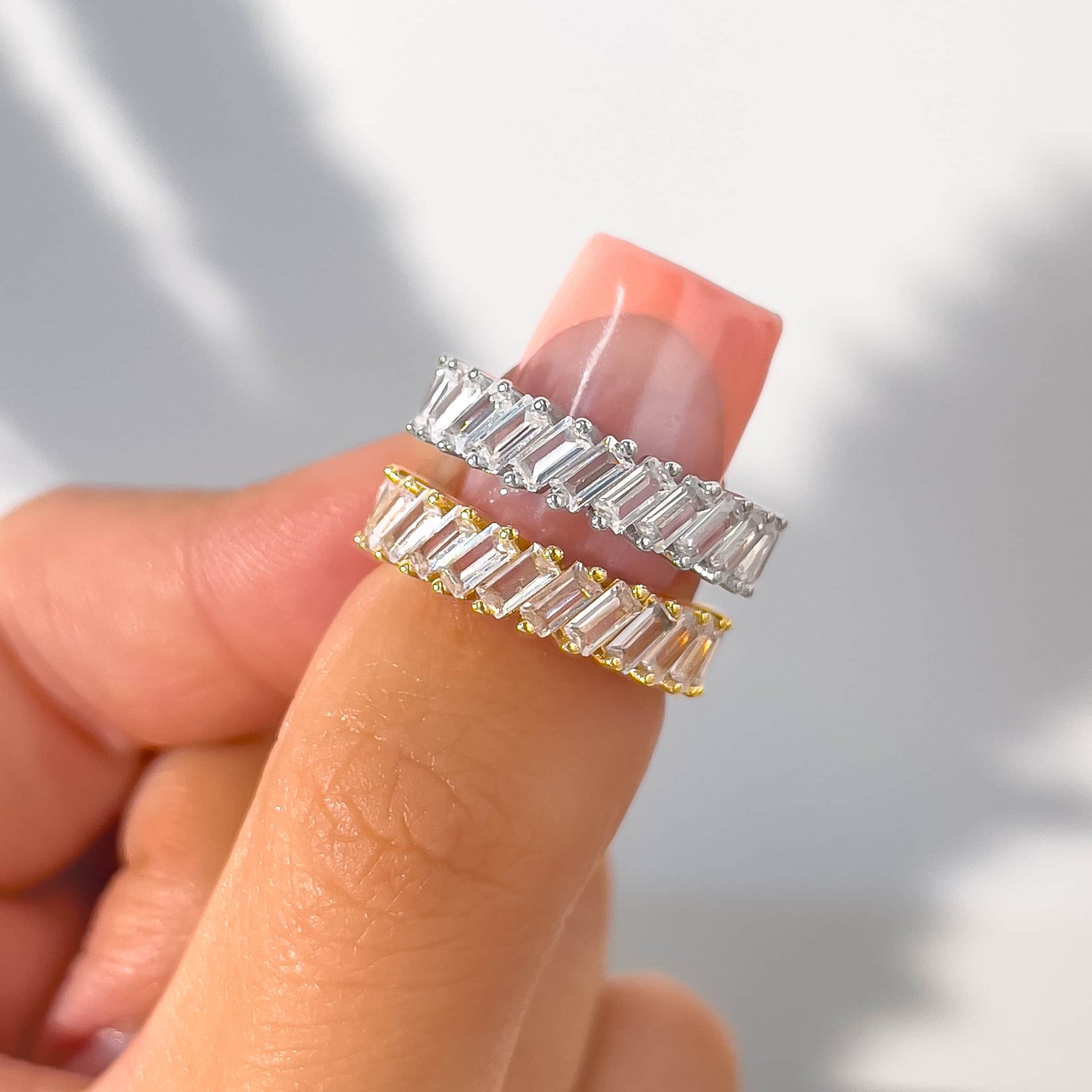 woman pinching silver and gold baguette band