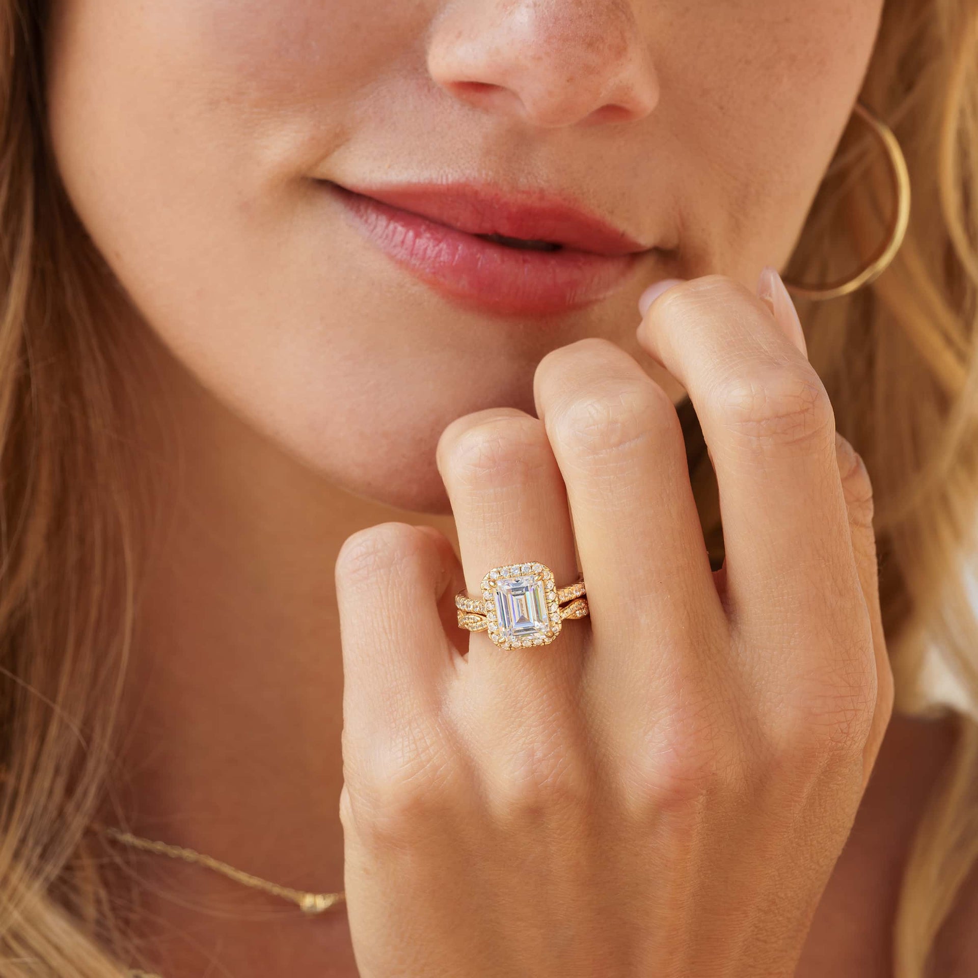 3 carat emerald cut engagement ring shown in gold paired with a vintage stunning gold wedding band shown on model 