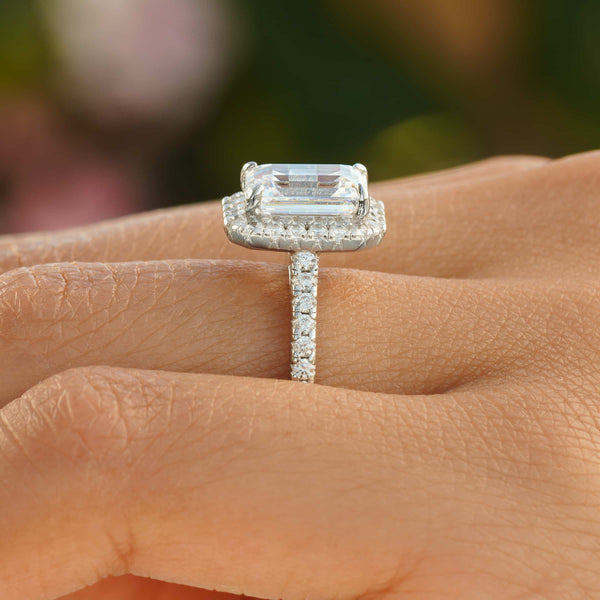Side profile of silver emerald cut engagement ring with half eternity band detailing 