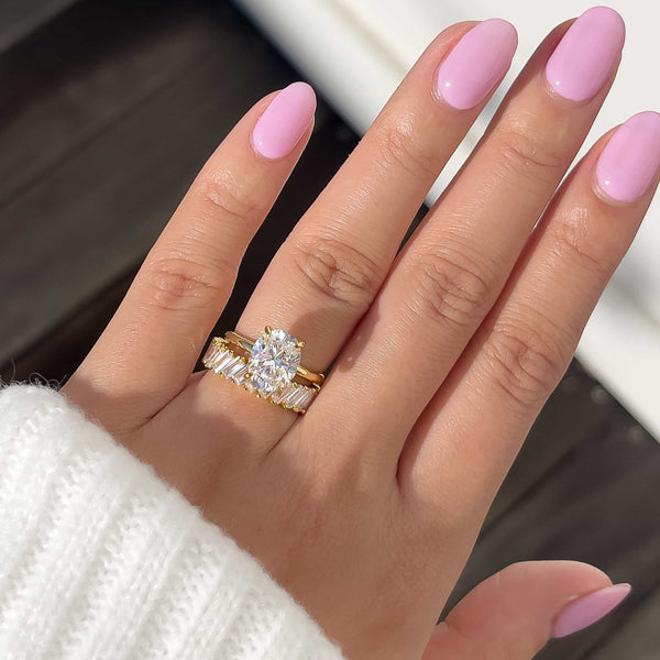 gold oval cut engagement ring on womans hand