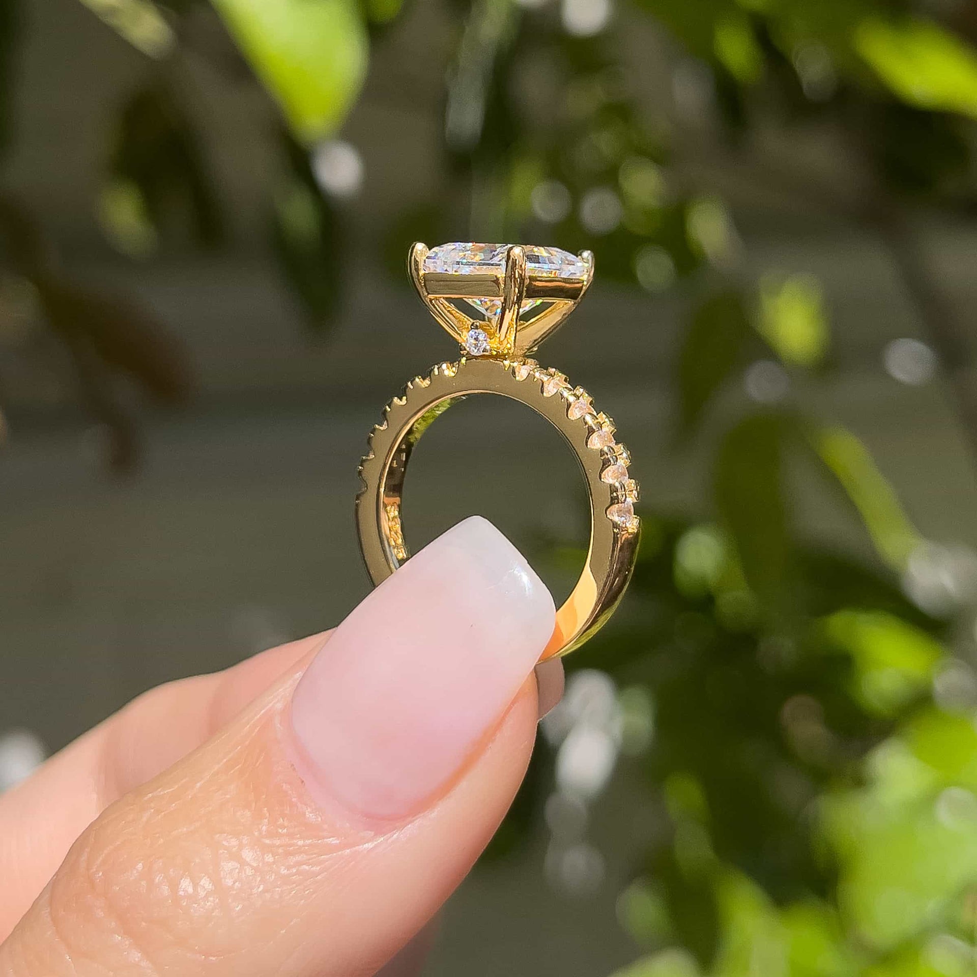 3.75 carat gold engagement ring setting shot shown in gold modeled on female with light pink nails and green background
