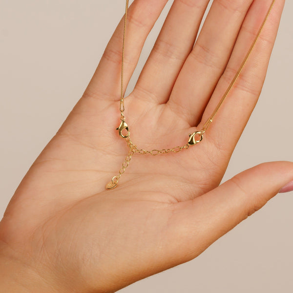 gold necklace chain extender on palm of hand
