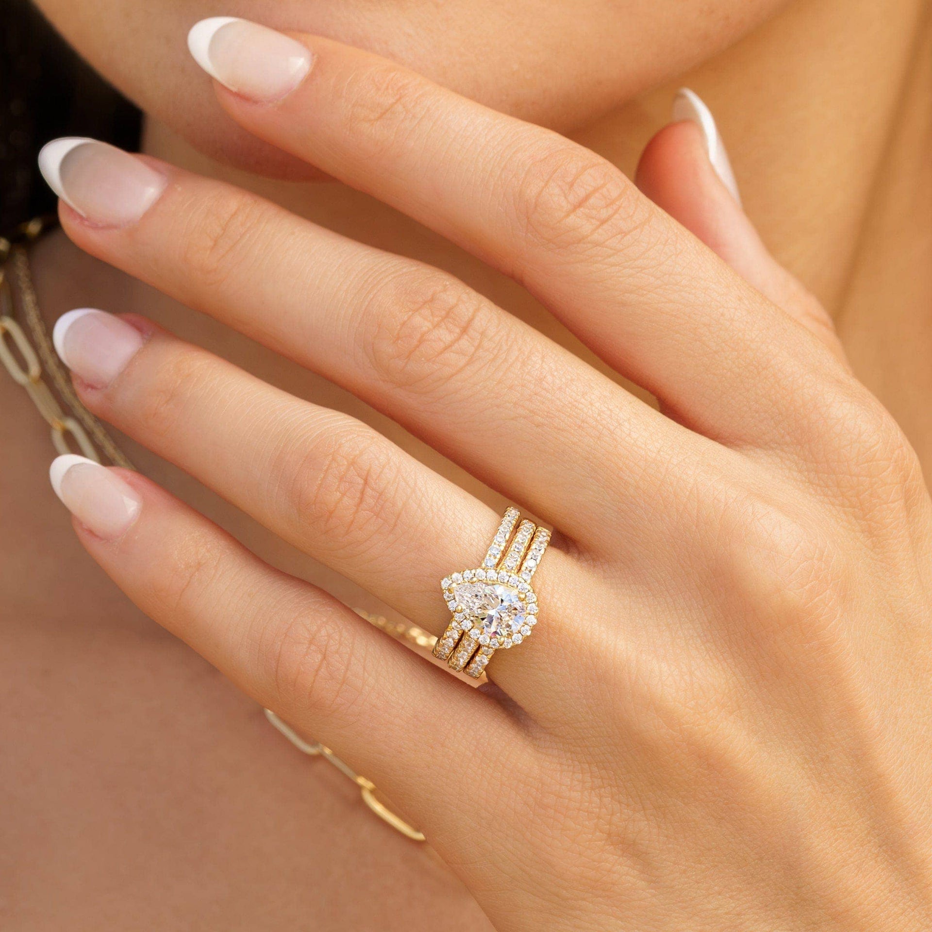 woman wearing gold pear shaped triple stack engagement ring