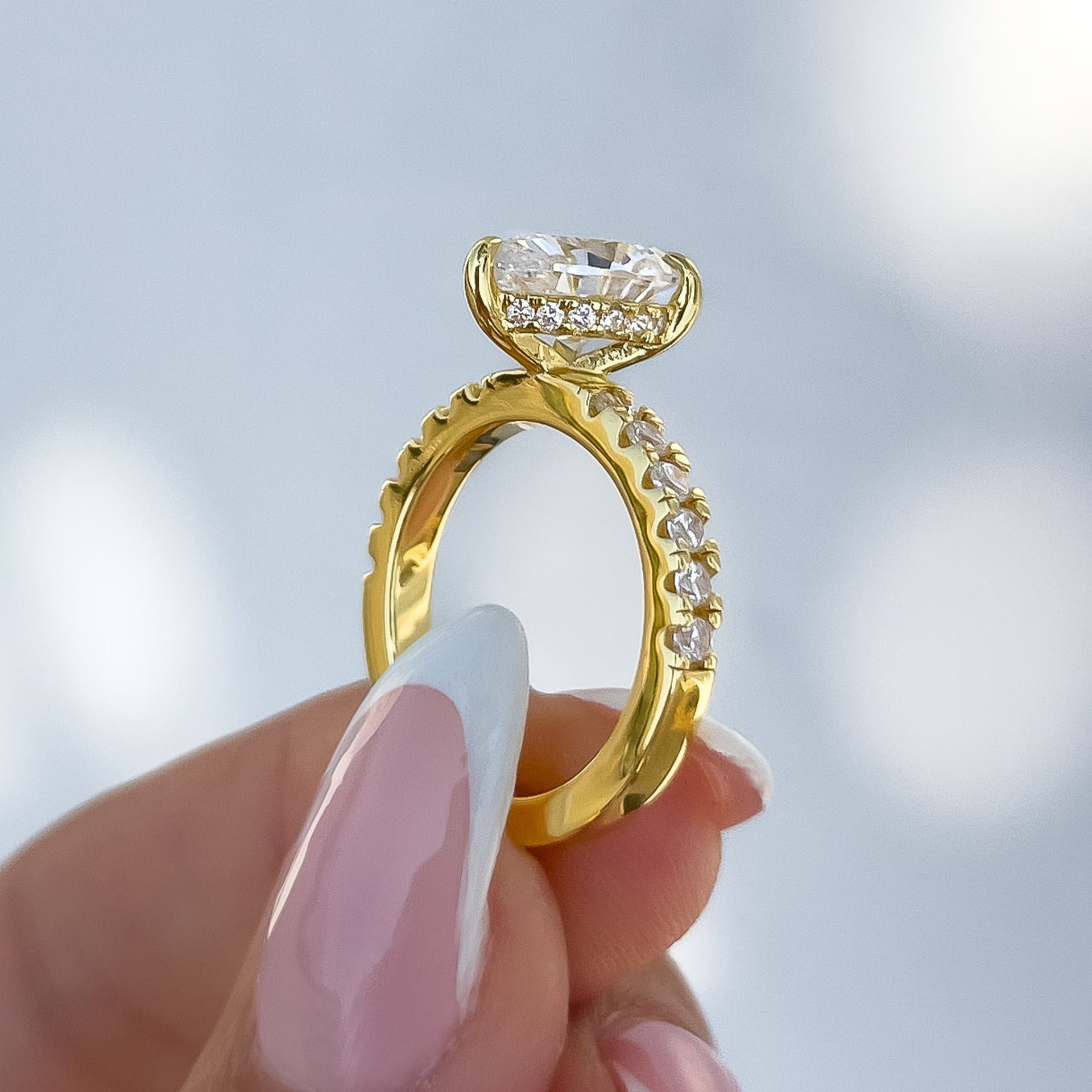 side view of gold 3 carat pear cut engagement ring with half eternity band