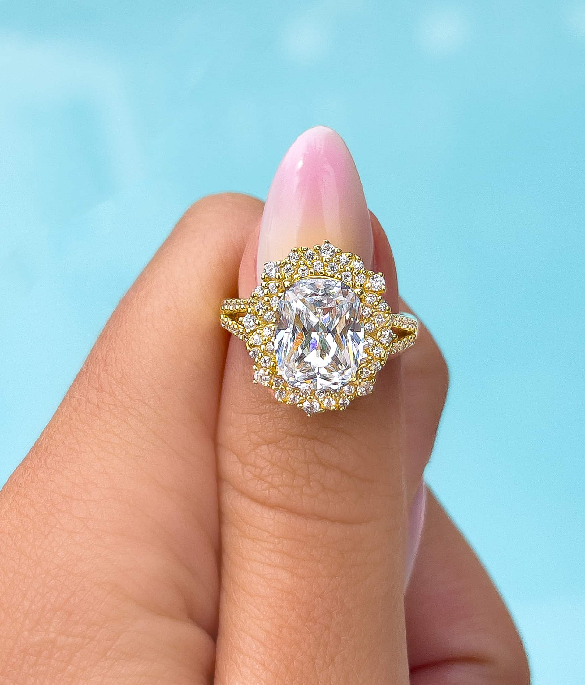 woman pinching gold vintage engagement ring by blue pool