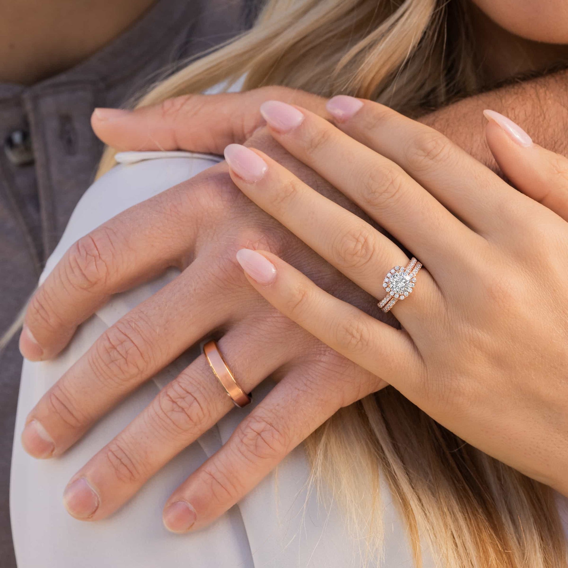 couple wearing rose gold wedding rings while holding hands