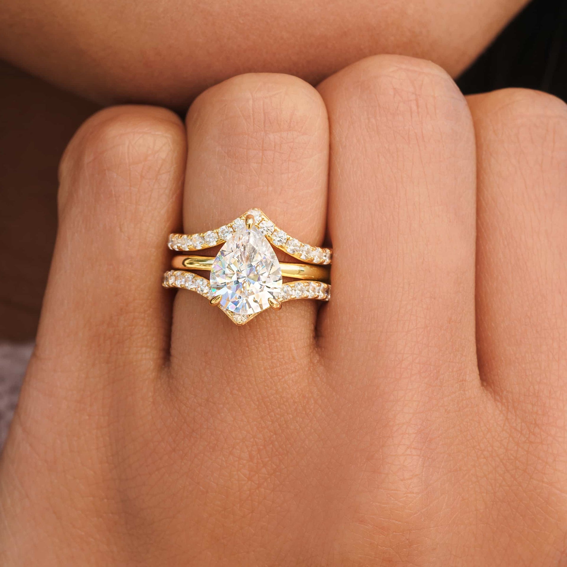 Unique gold half eternity wedding bands stacked with a stunning gold pear cut engagement ring
