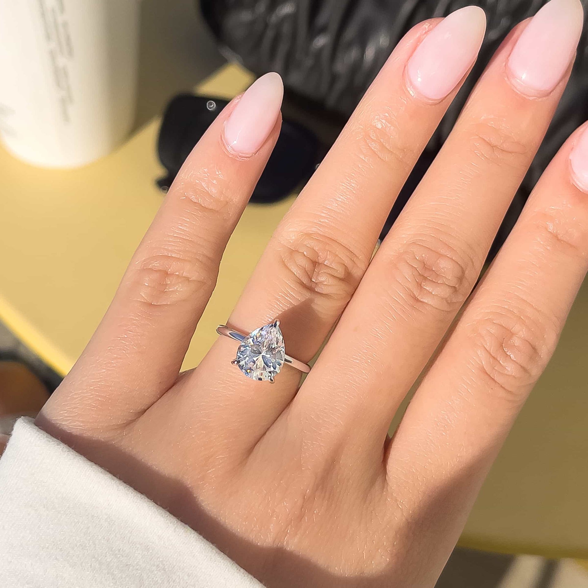 silver pear cut engagement ring on woman's hand