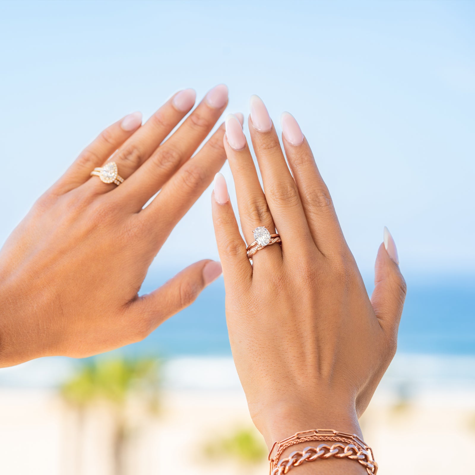 POV of girls holding hands to sky with gold and rose gold engagement rings