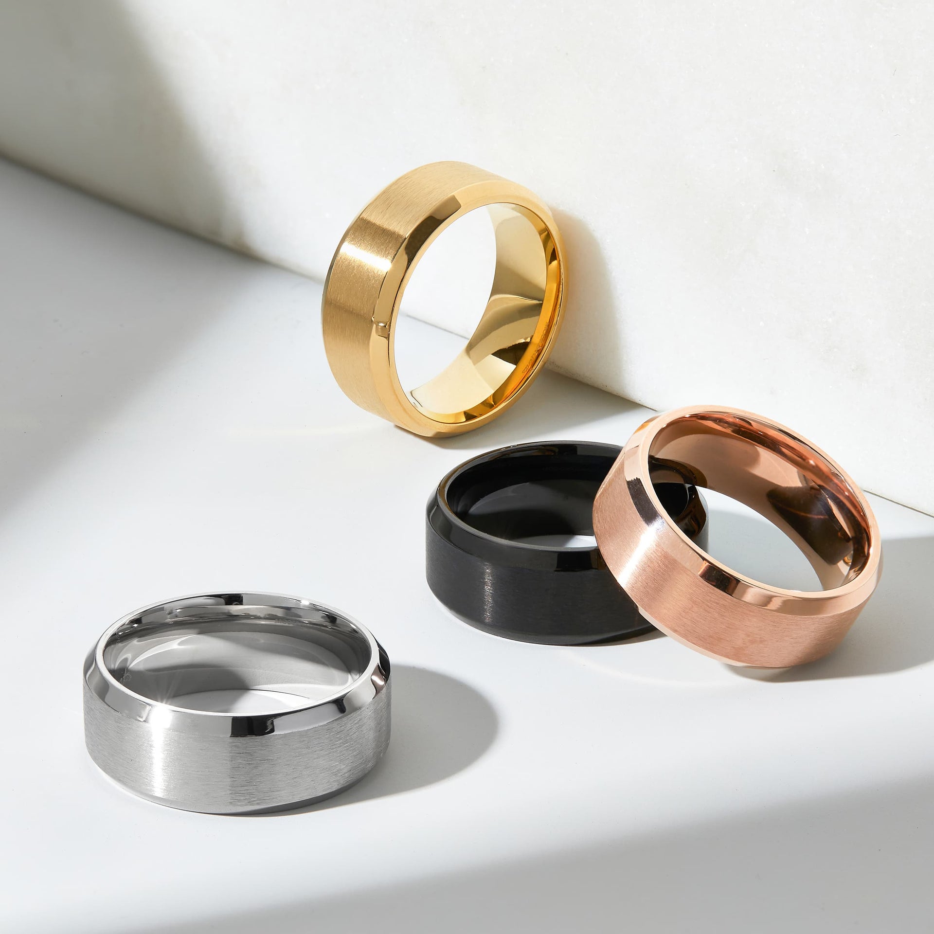 all titan wedding bands in silver, gold, black, and rose gold on a white background