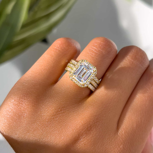 woman wearing gorgeous wedding ring stack with emerald cut engagement ring