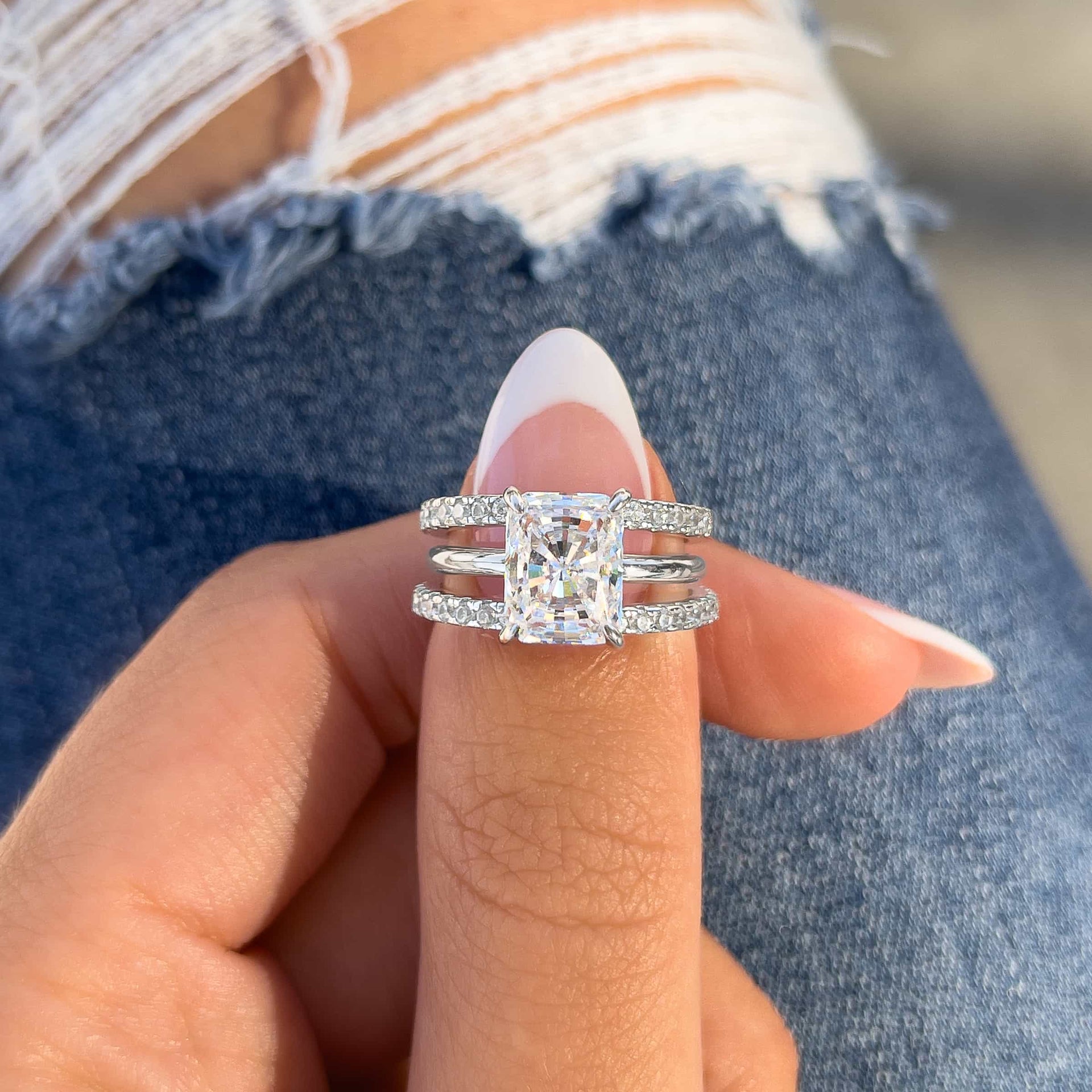 woman pinching promise wedding band stack with radiant cut engagement ring