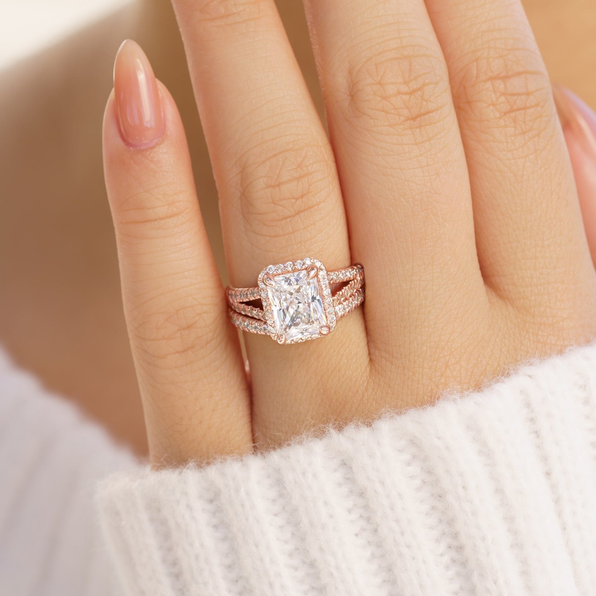 classic rose gold wedding ring set with 3.5 carat radiant cut center stone on female model with white knit sweater