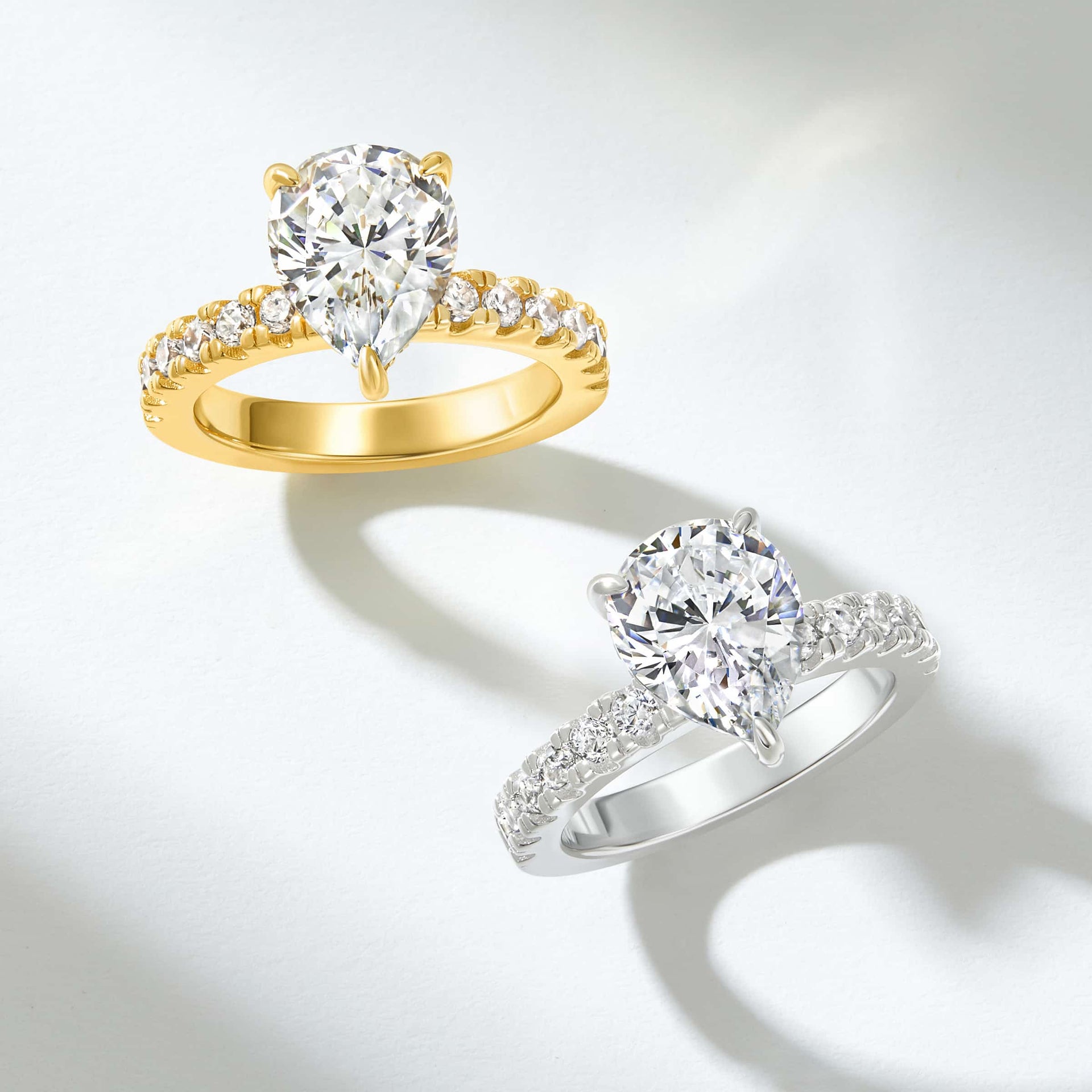 stunning visual of a 3 carat pear cut half eternity engagement ring shown in gold and silver