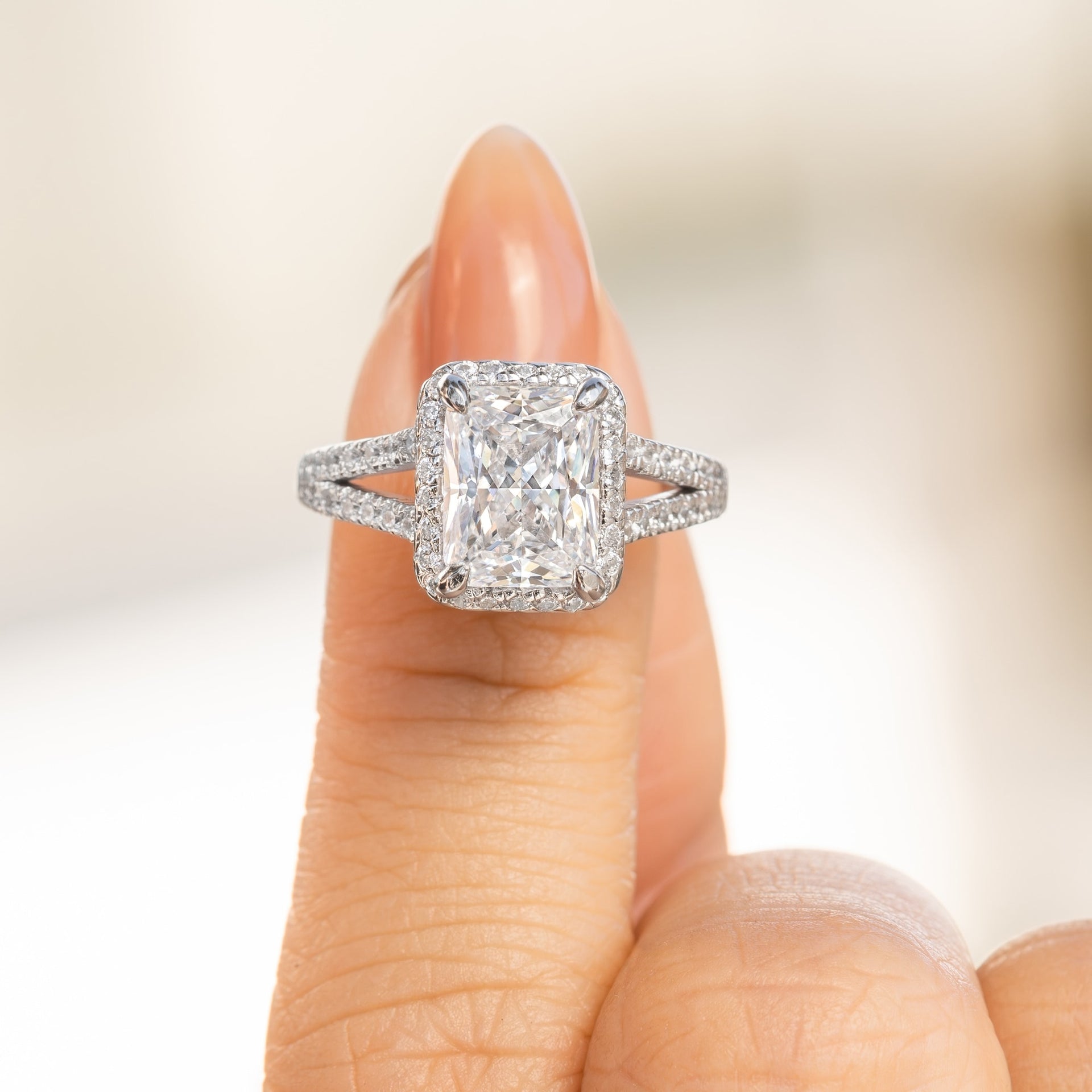 stunning 3.5 radiant cut engagement ring with halo and split shank detailing on female hand