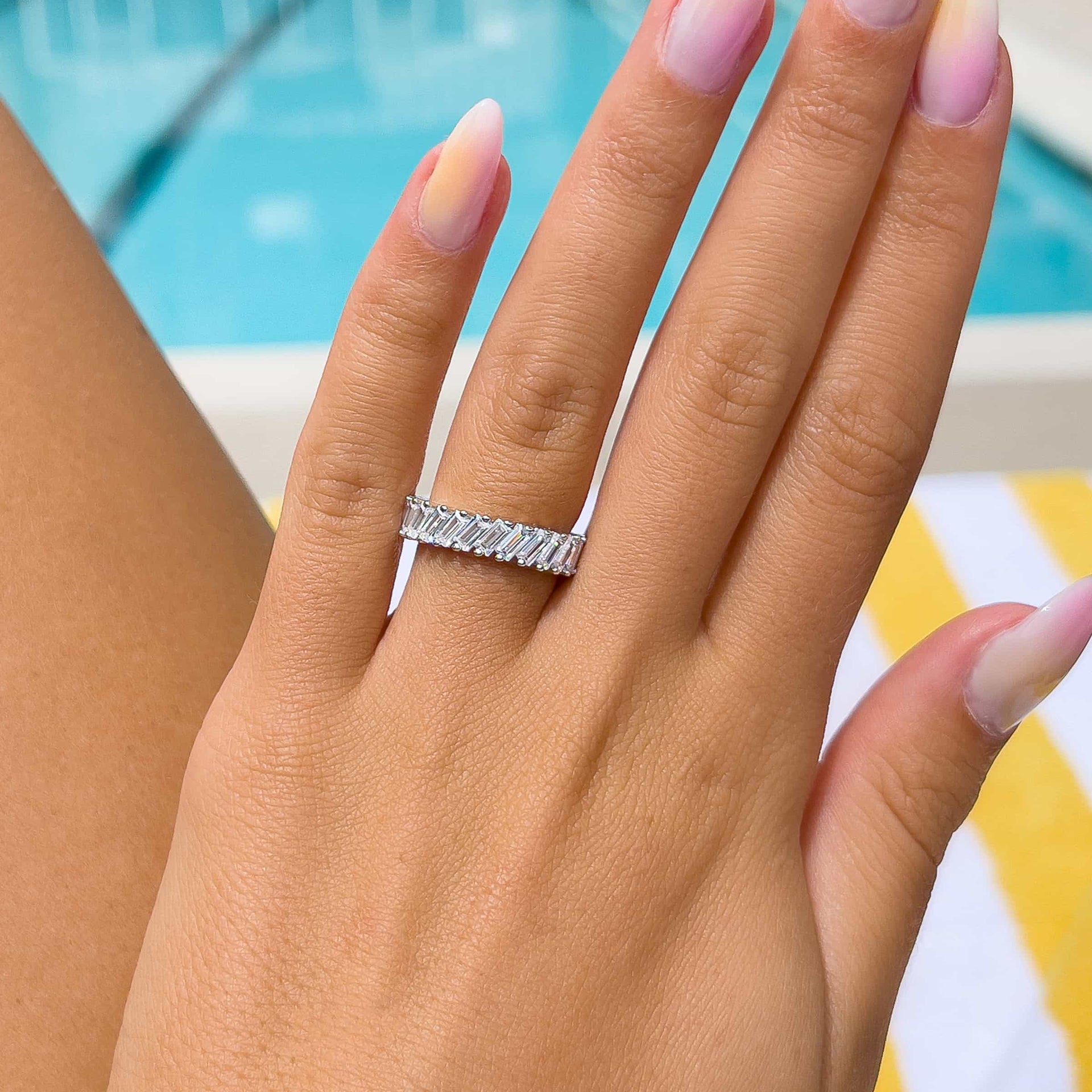 woman wearing trendy affordable silver wedding band by pool