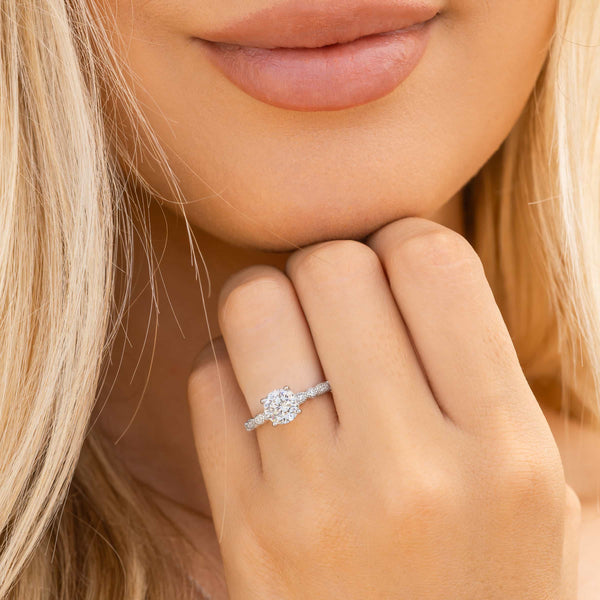 woman wearing silver round cut engagement ring