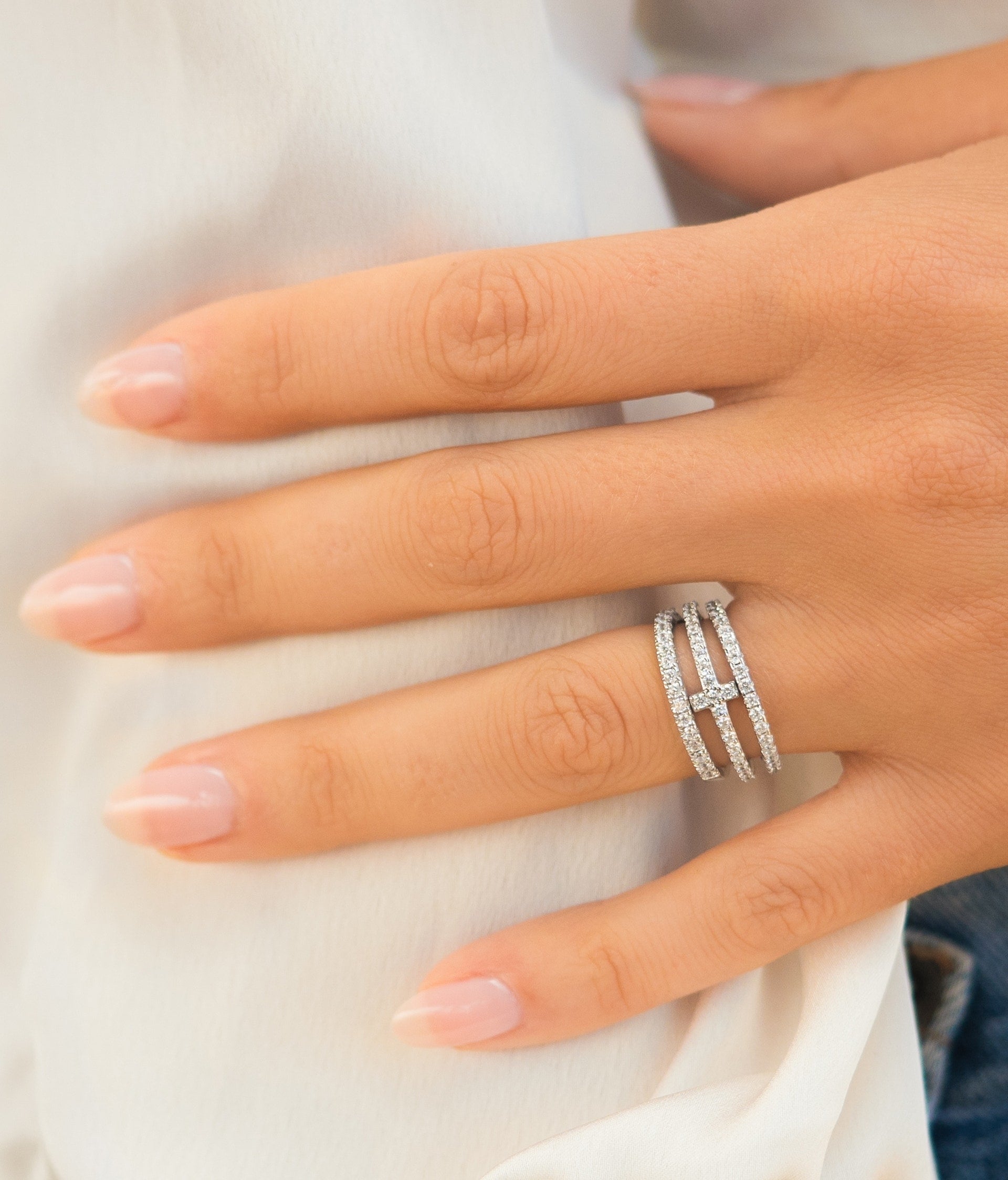 woman wearing three silver wedding bands in a stack