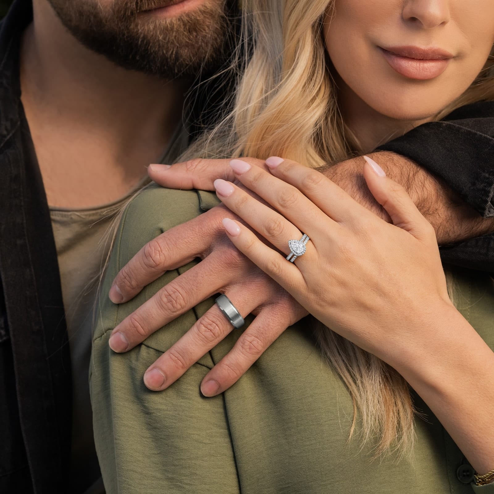 couple holding hands wearing silver engagement rings