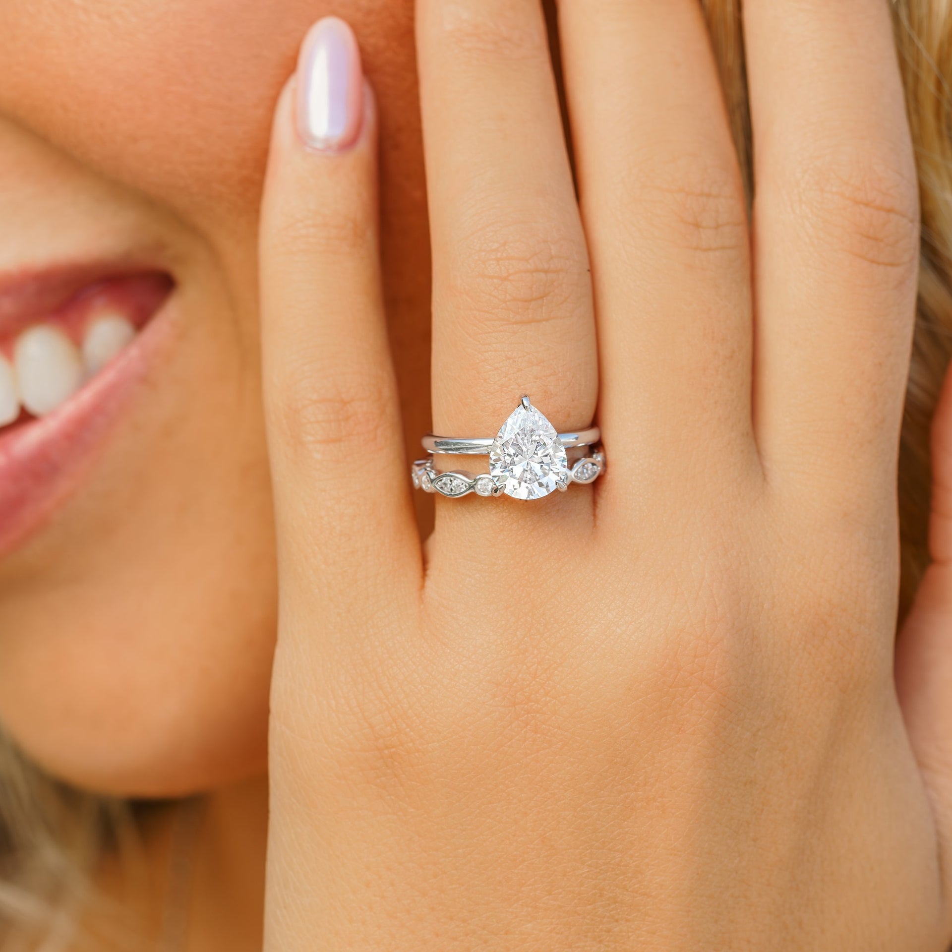 woman wearing silver engagement ring with silver wedding band