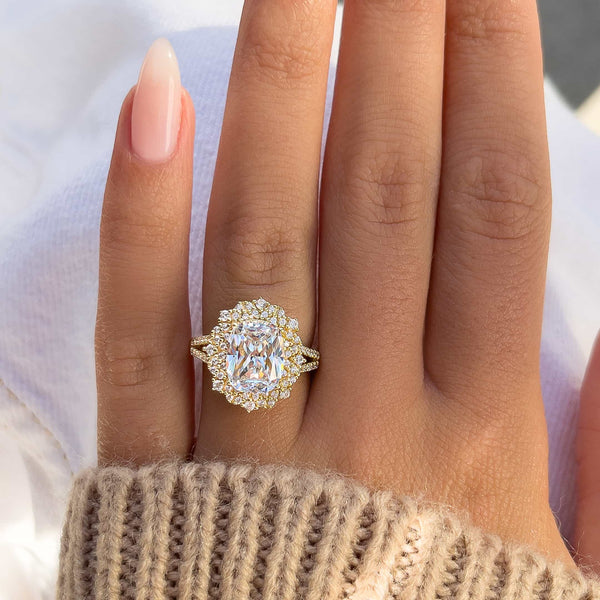 stunning gold cushion cut engagement ring with white jeans and a brown sweater