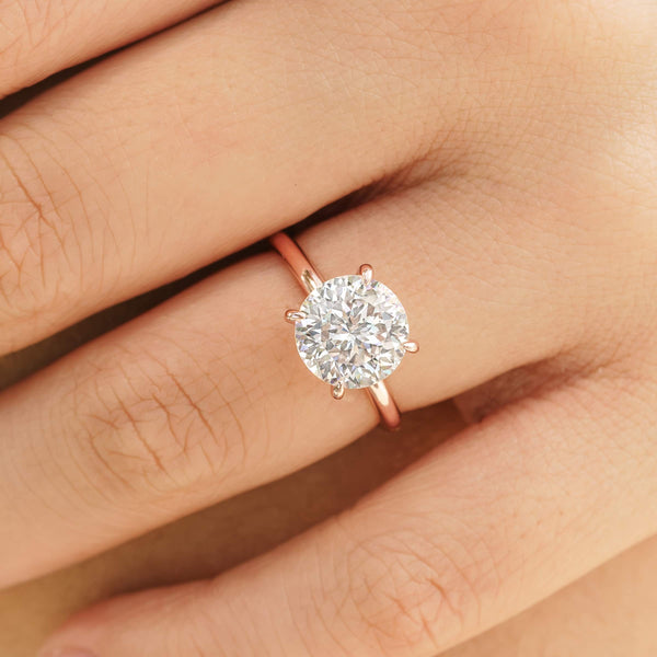 woman wearing round cut rose gold engagement ring